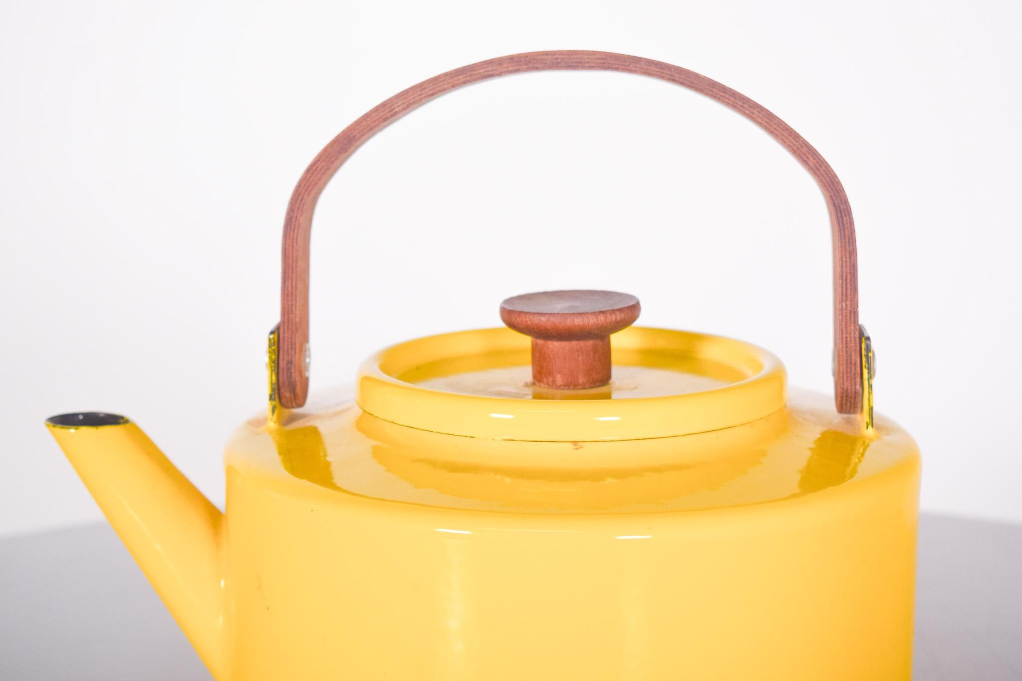 Yellow kettle, Michael Lax, Copco in enamel and teak. Yellow Copco kettle, designed by Michael Lax, model no. 117 and made in Spain. 
It's made of metal with bright yellow enamel on the outside and a dark interior, and the handle and lid knob are