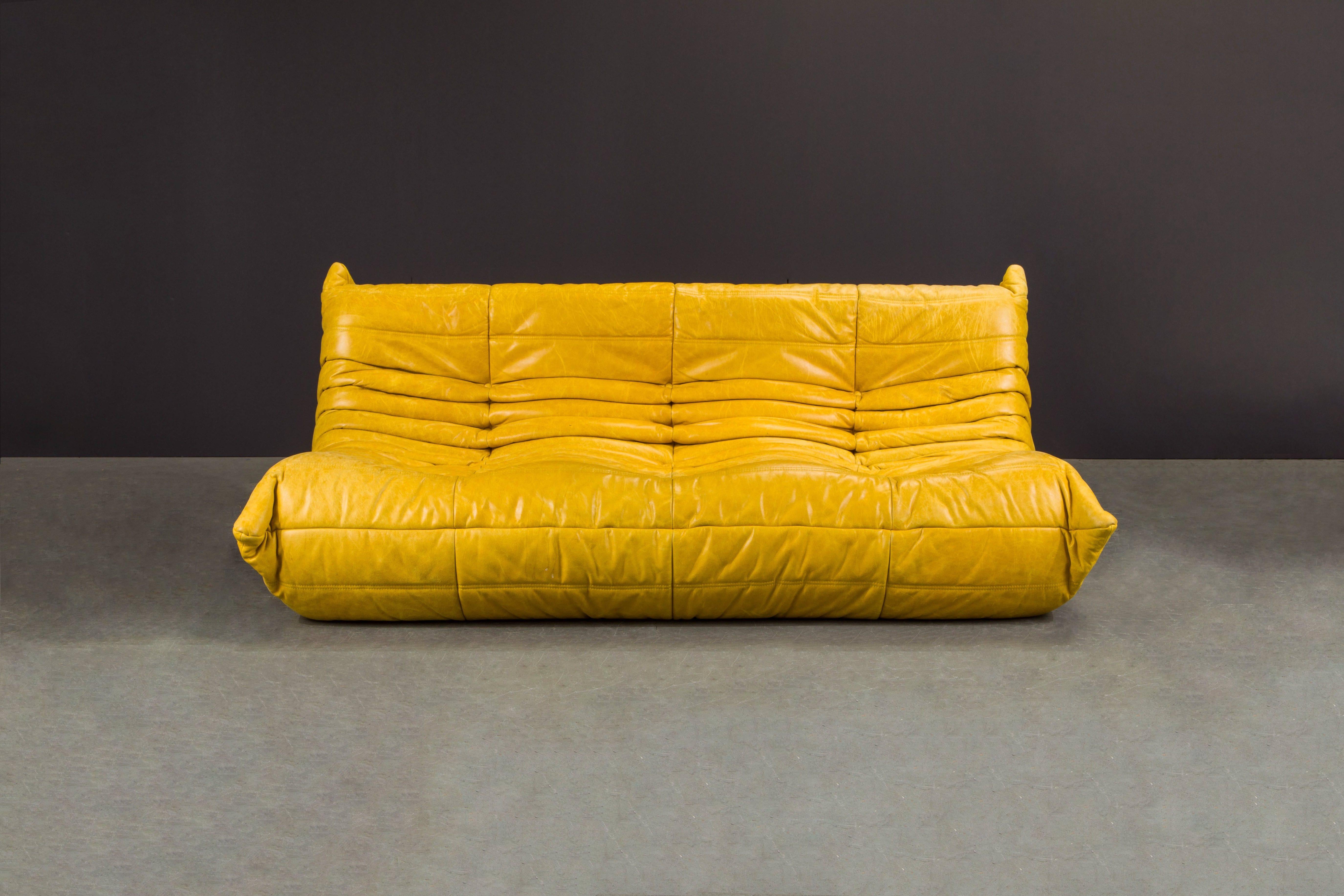 This gorgeous yellow leather 'Togo' three-seat sofa was designed by Michel Ducaroy in 1973 for Ligne Roset, France. Signed with Ligne Roset Made in France label and has the standard striped underside decking fabric which Ligne Roset uses. Originally