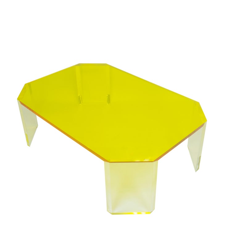 Our octagon table is a large squared coffee table with angled legs made entirely of Lucite. The top features a vibrant yellow color that leaves a softl glow underneath it. The beveled legs are crafted with clear Lucite. 
This piece is built to