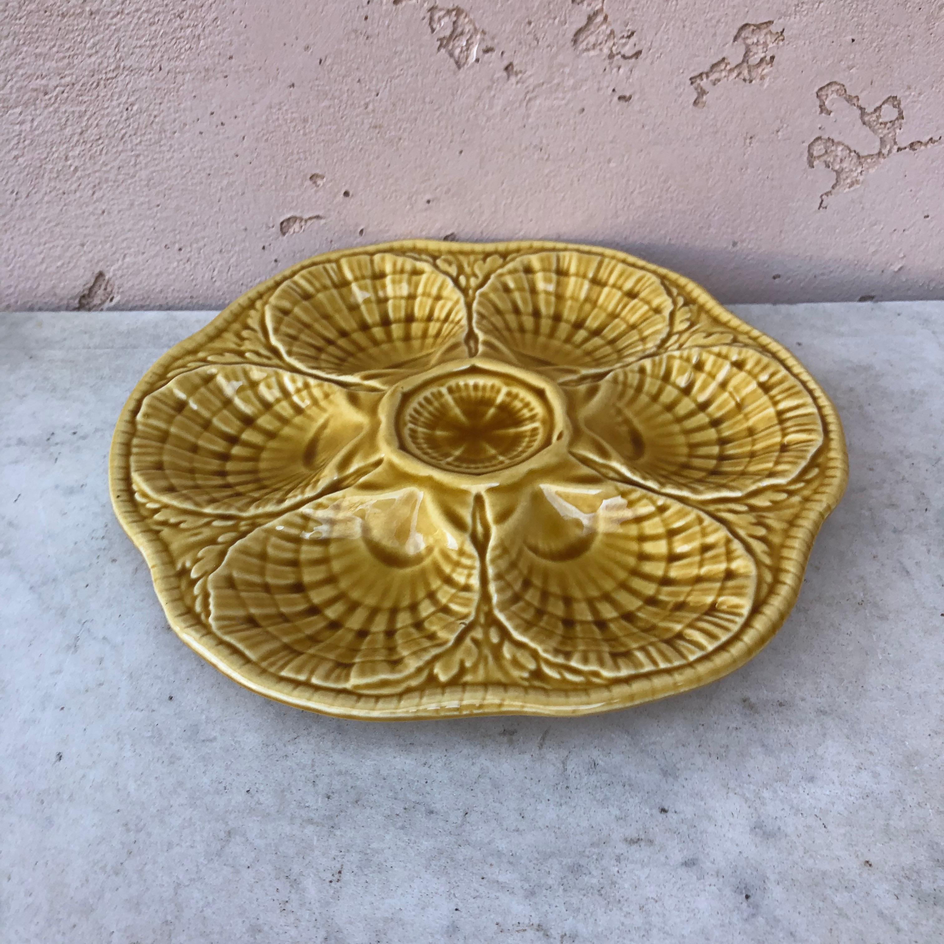 Majolica oyster plate signed Sarreguemines, circa 1930.
Yellow mustard color.
 