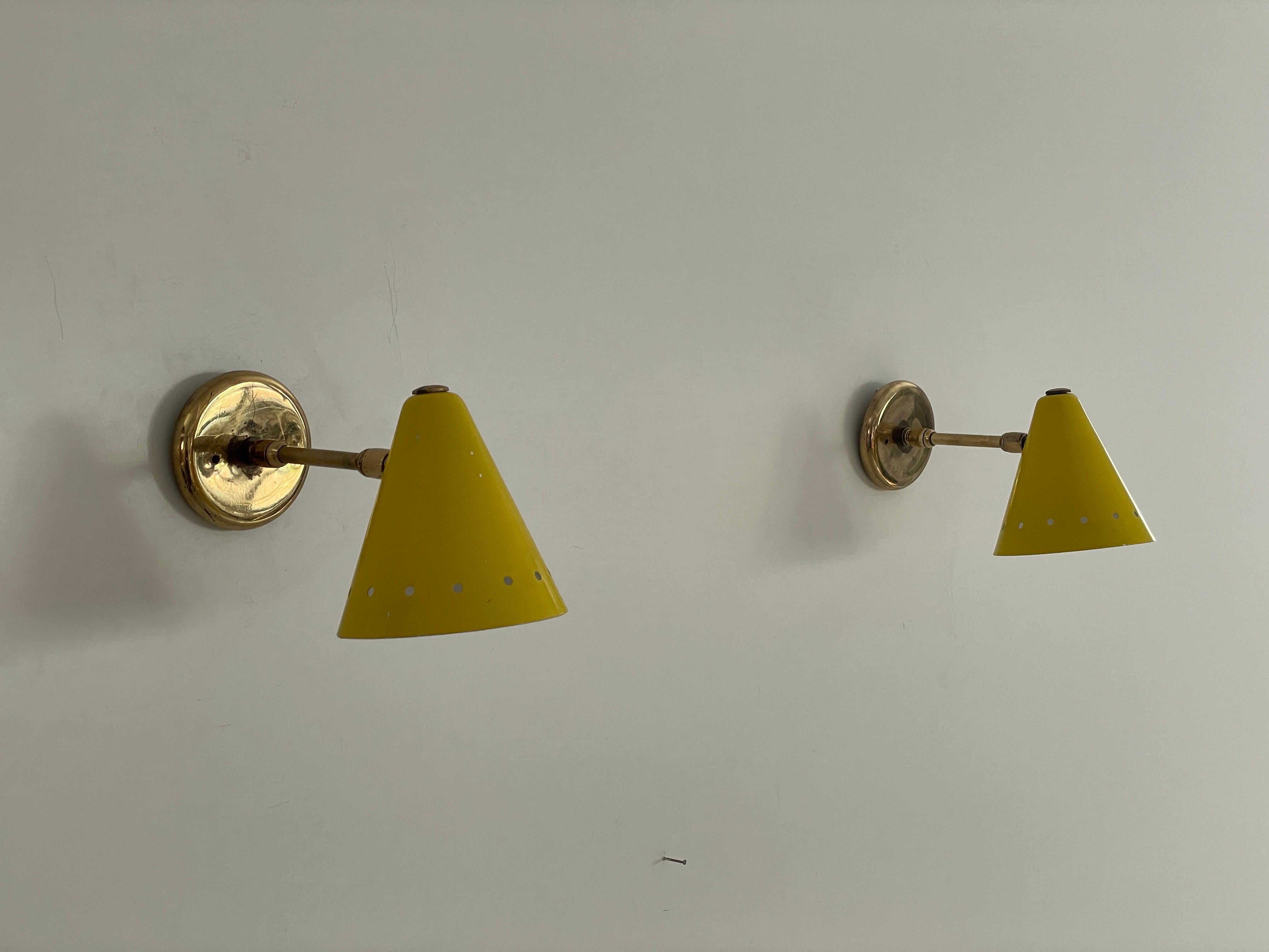 Paar Wandlampen aus gelbem Metall und Messing, 1960er Jahre, Italien

Der Lampenschirm ist in sehr gutem Vintage-Zustand.

Sowohl der Kopf als auch die Stange sind einstellbar

Diese Lampe funktioniert mit E14-Glühbirnen. 
Verkabelt und geeignet für