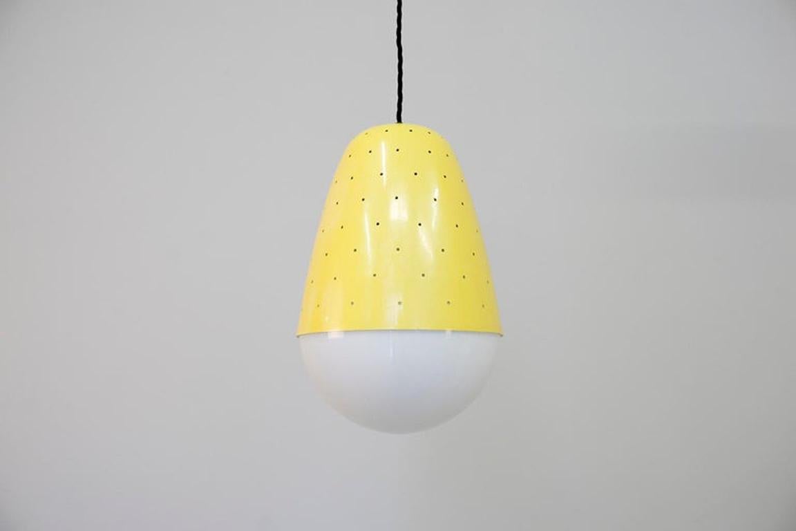 Pendant lights model no. '2079' with a perforated yellow lacquered metal construction and opaline glass.
Dimensions: H. 30 cm Ø20 cm 
Design: Gino Sarfatti 1955 for Arteluce Italy.
Cf. Gino Sarfatti, MarCo Romanelli, Sandra Severi, 1938 – 1973