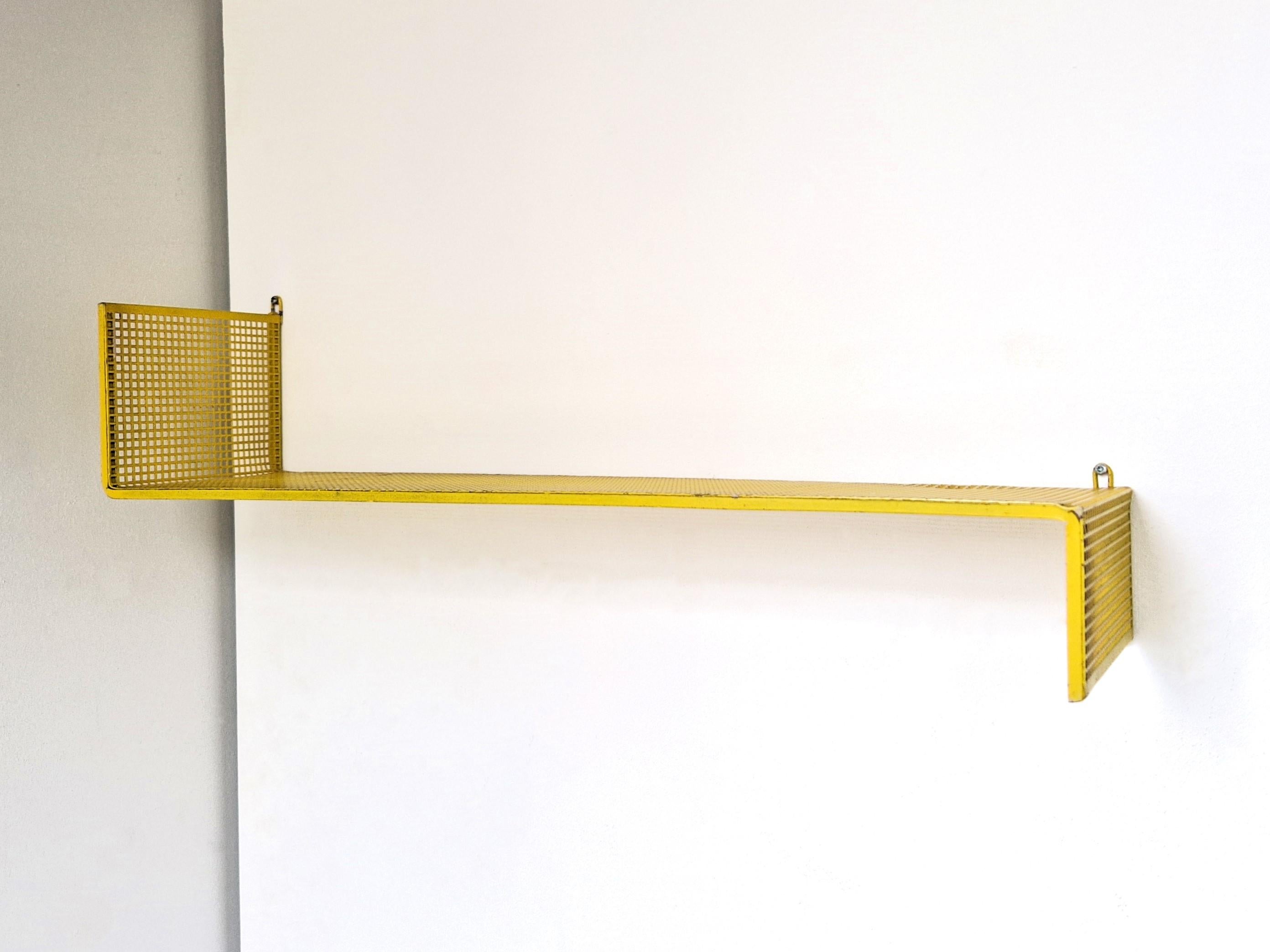 This amazing and rare wall shelf was designed by Mathieu Matégot for Artimeta in the 1950's. It is made out of yellow lacquered perforated metal.  The shelf is in a good original condition and it has a beautiful patina of age and use. This is a