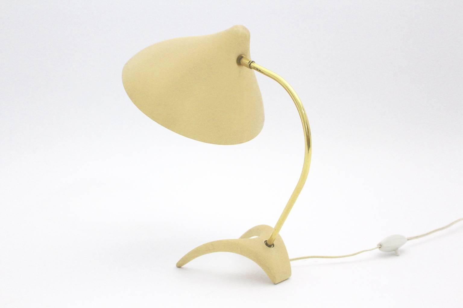 A lovely yellow mid century modern vintage table lamp, which shows a cast iron foot with a curved brass stem.
Designed by Louis Kalff in the 1950s for Philips Netherland.

The conical shade was made ofyellow lacquered aluminum. The table lamp has an
