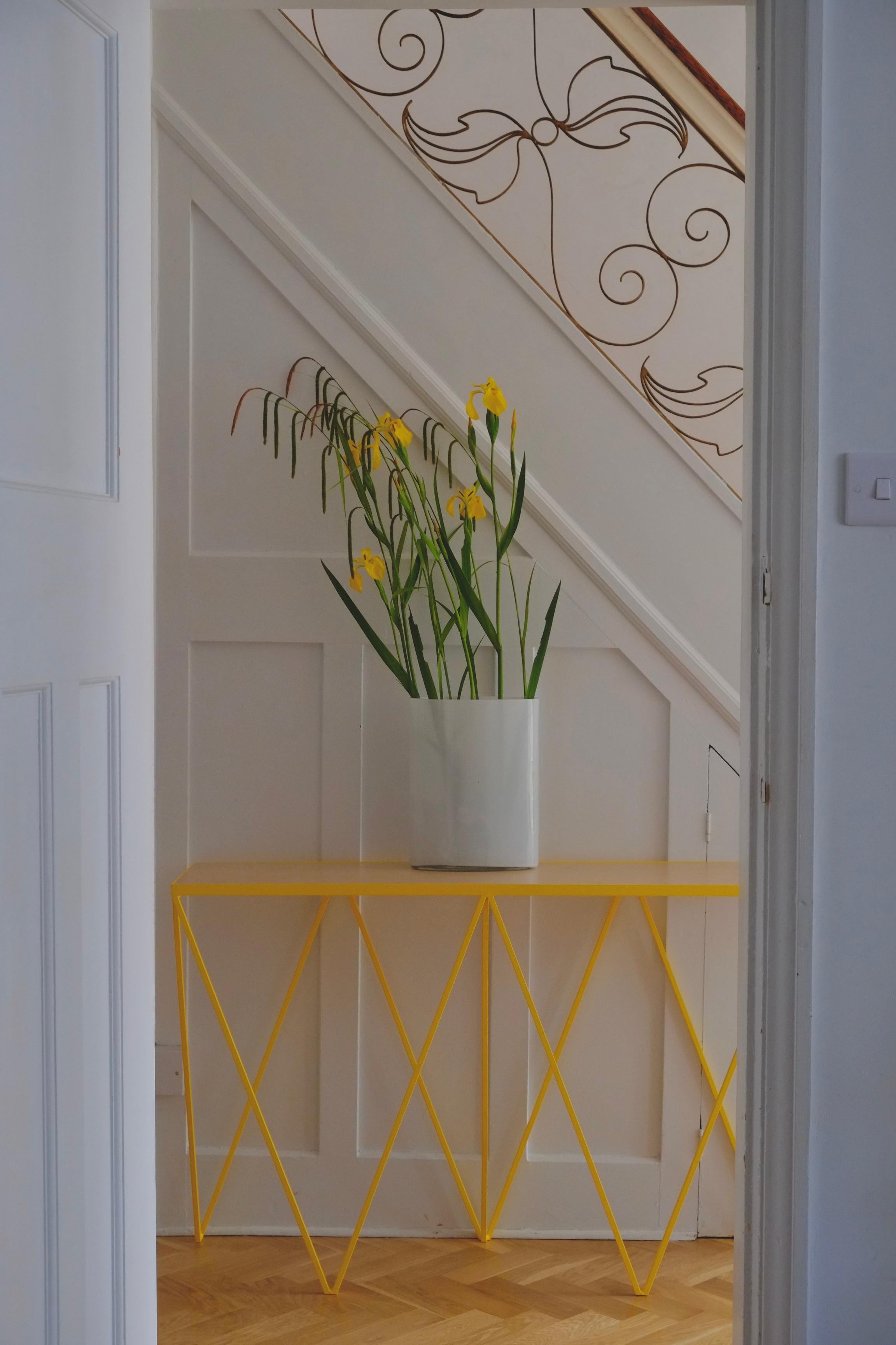 This Giraffe console table is made with a yellow powder-coated steel frame and a natural granite stone top. This luxury console has been designed to be geometric and compact with beautiful proportions. A perfect statement piece for the hallway or