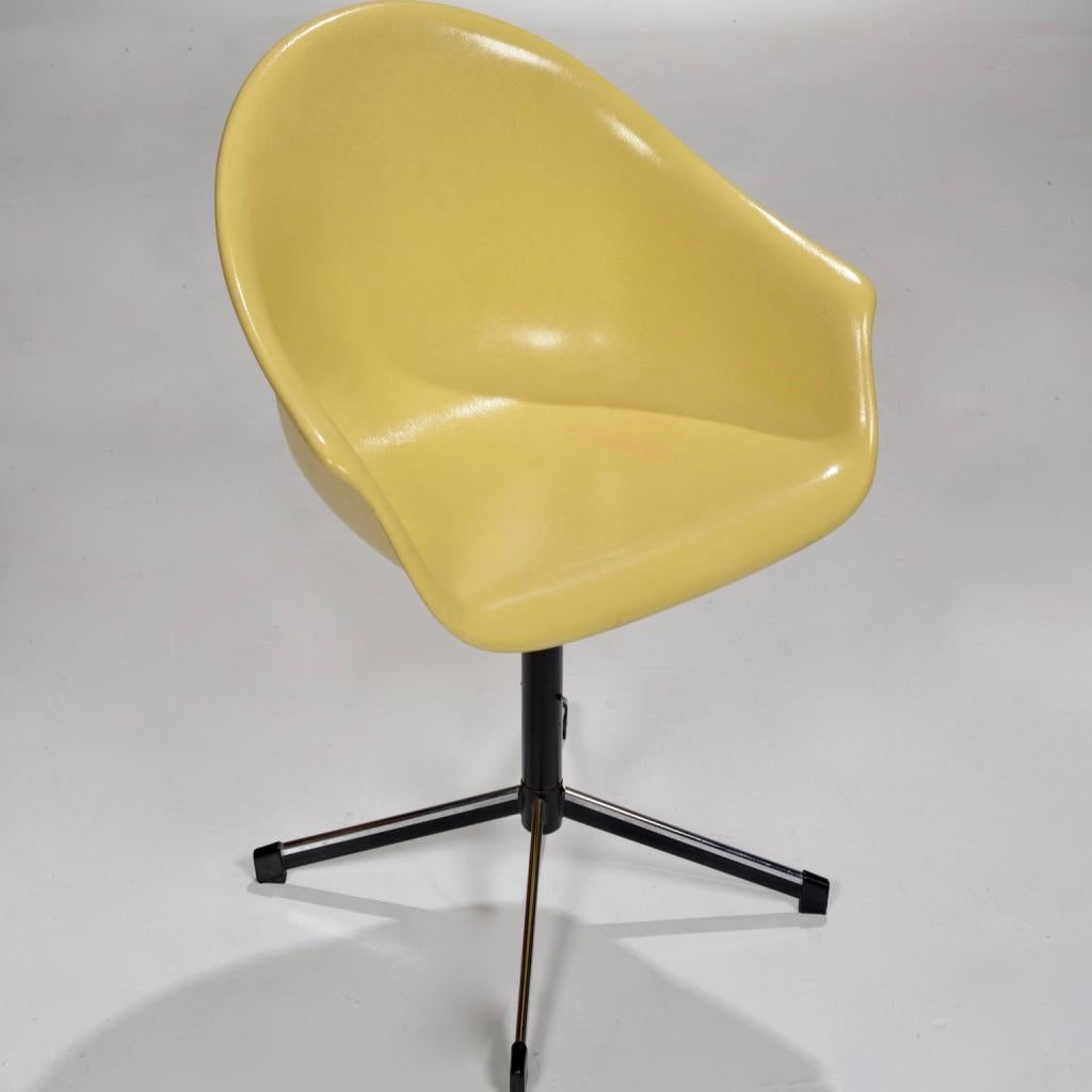 Yellow molded fiberglass swivel shell chair with arms and black metal four-legged base. 
This chair is in beautiful condition and makes for a perfect desk chair.