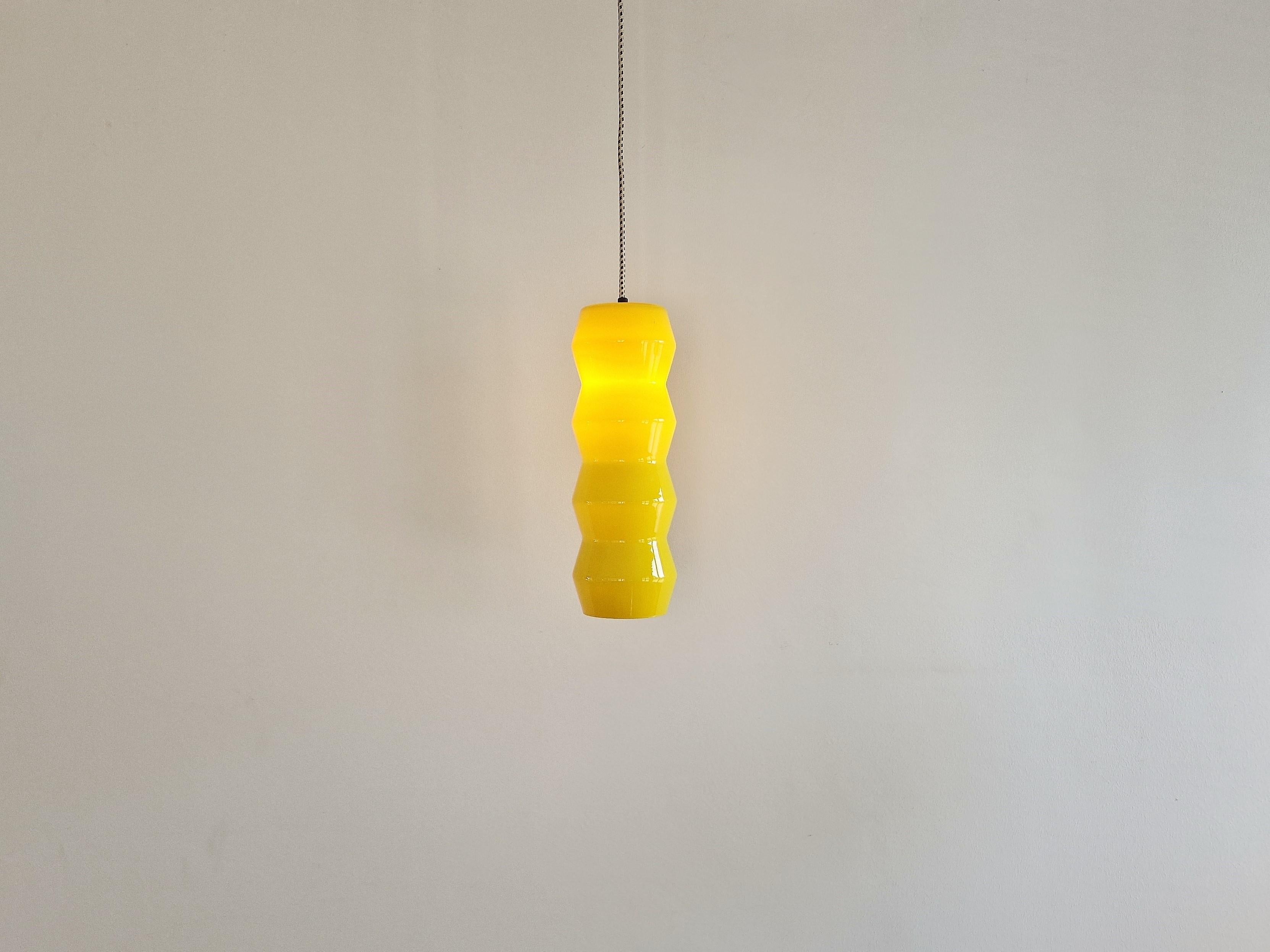 Cette étonnante lampe suspendue en verre façonné est documentée dans un catalogue de la société 'Indoor'. Il s'agissait de l'importateur et du distributeur de marques de luminaires telles que Vistosi, Venini et Arteluce aux Pays-Bas. Le catalogue de