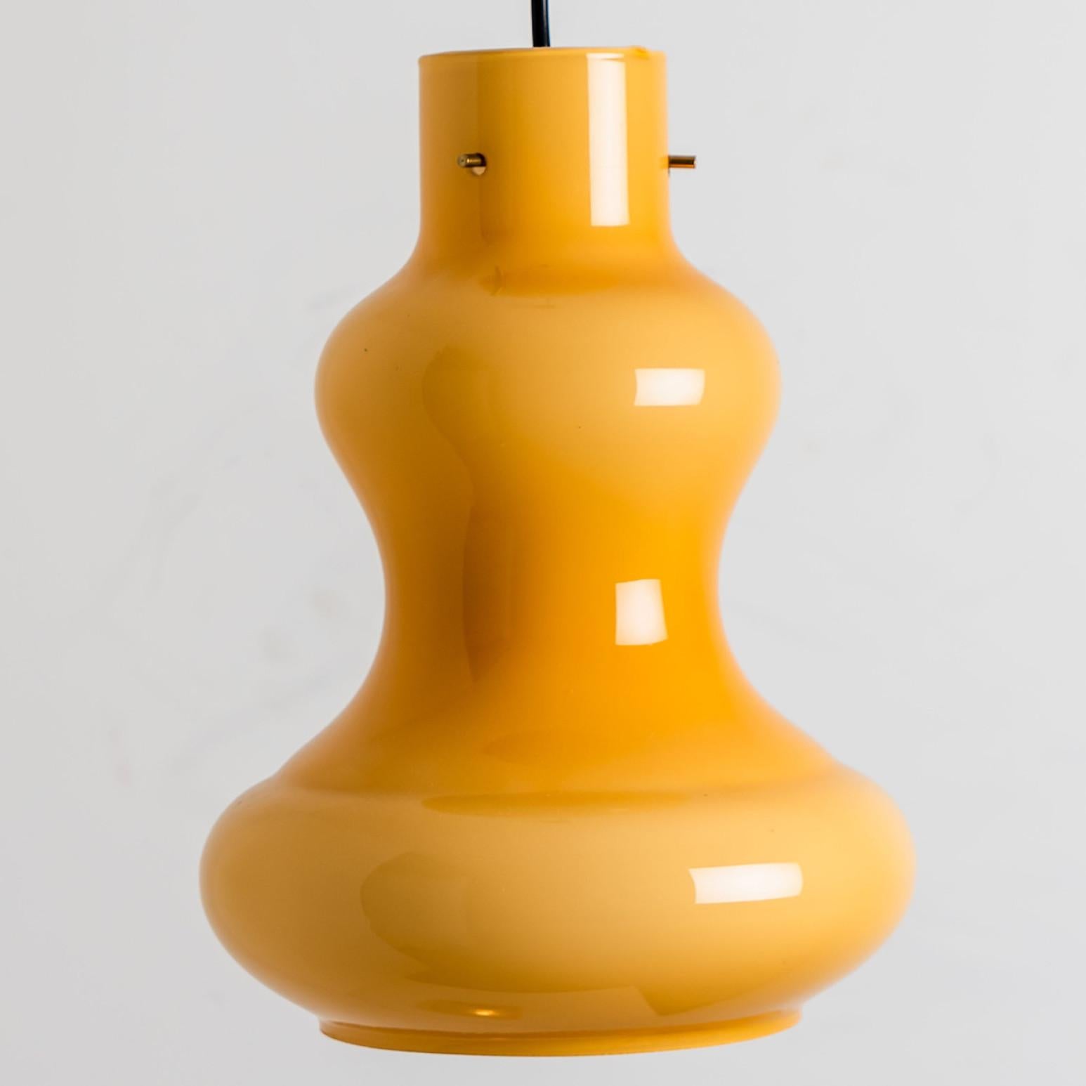 Eine schöne Pendelleuchte aus gelbem Glas, die in den 1960er Jahren von Massimo Vignelli für Venini hergestellt wurde.
Der Lampenschirm besteht aus gelbem Opalglas mit einer weißen Innenglasur. Echtes Muranoglas, hergestellt in Italien.

Wir haben