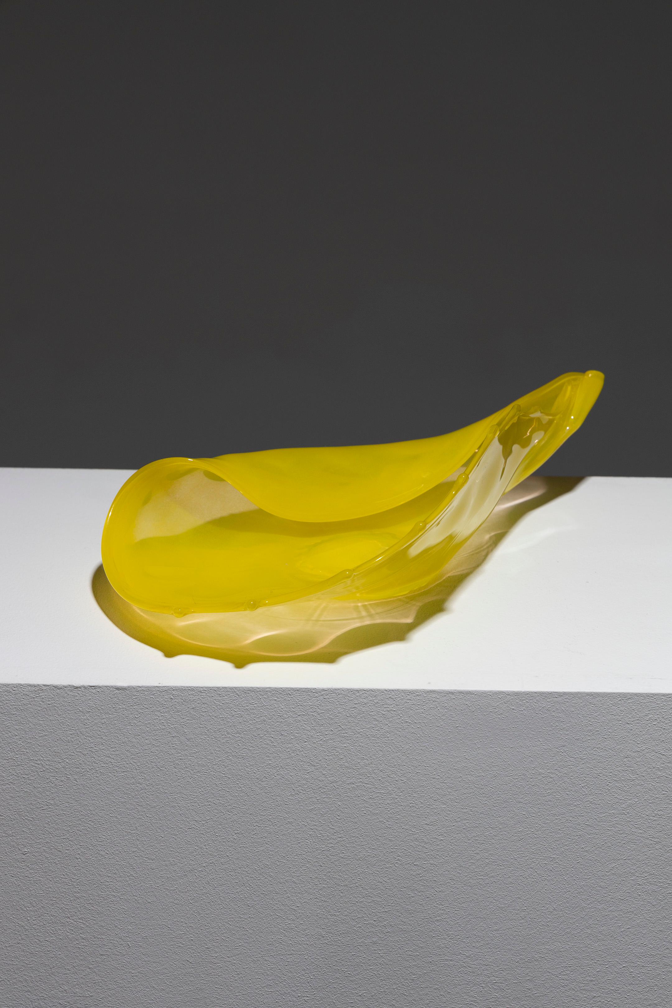 Cuenco de concha de cristal de Murano teñido de amarillo de Luigi Mellara, años 70. De forma redondeada, con el borde exterior curvado hacia dentro, que contrasta con la sección curvada adornada con pinchos, que culmina en el ápice de la concha. Muy