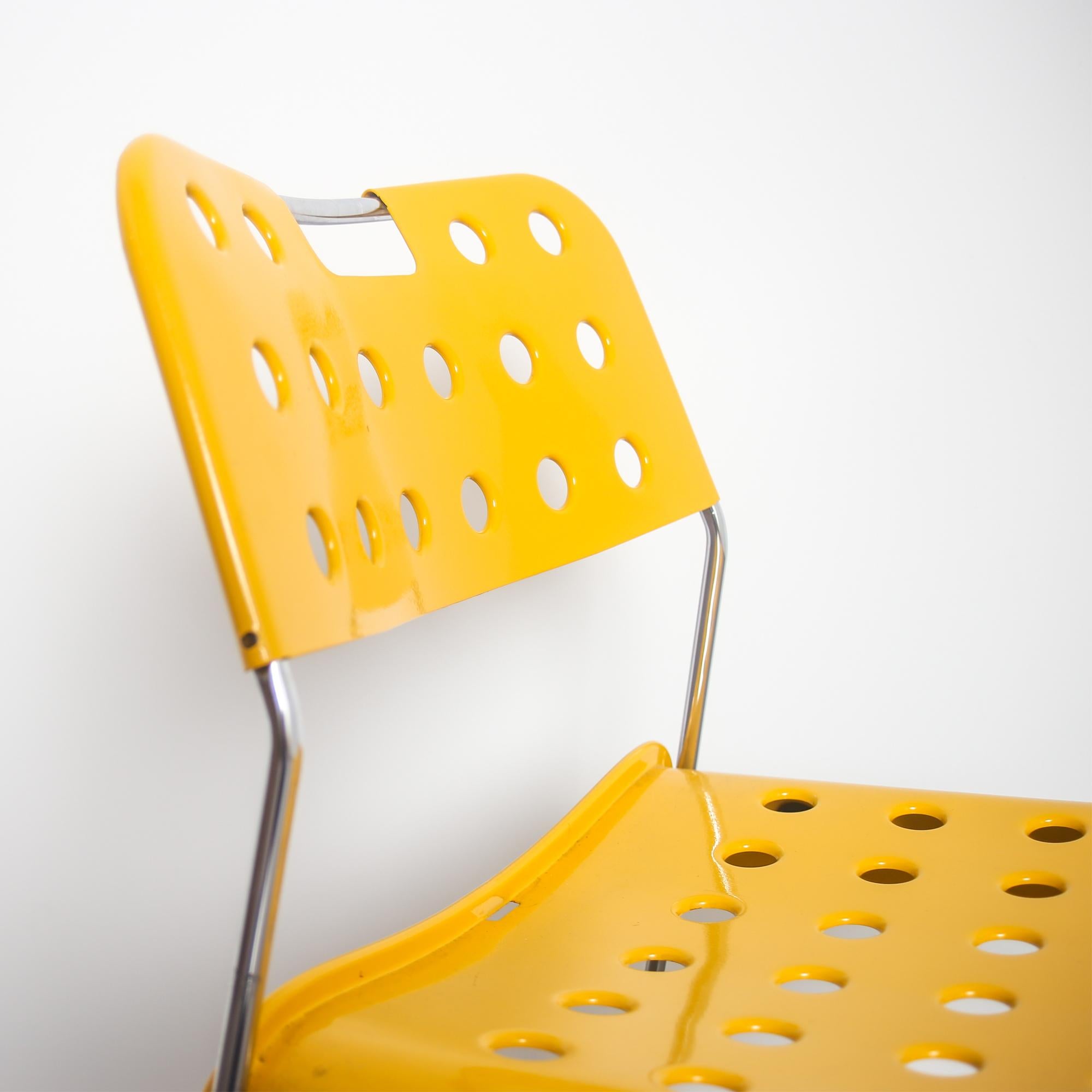 This yellow 'Omstak' model chair was designed by Rodney Kinsman, and manufactured in Italy by Bieffeplast in 1972. It is made from iron and steel, and features a yellow lacquered metal seat and backrest with perforated details. This item is in a
