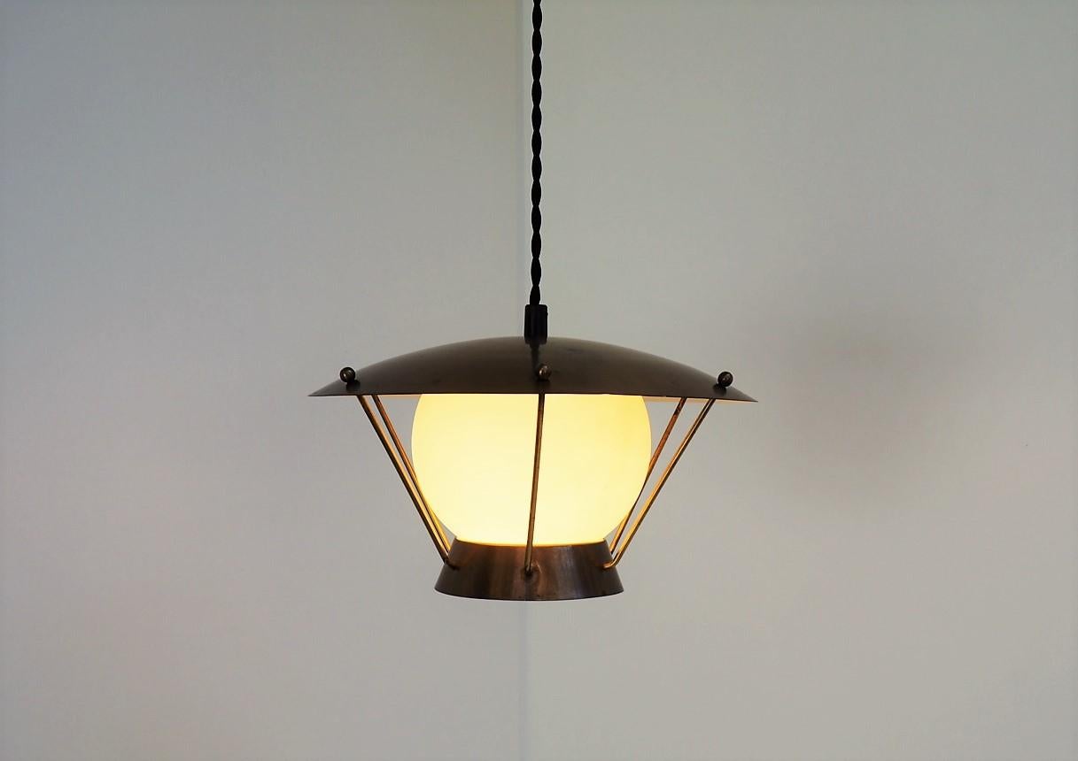 Adorable pendant from the 1930s made in yellow opaline glass, solid brass shade and held together with brass rods. The pendant is Danish vintage design from the 1930s and could be made by Fog & Morup or Lyfa.

The round glass shade is being held