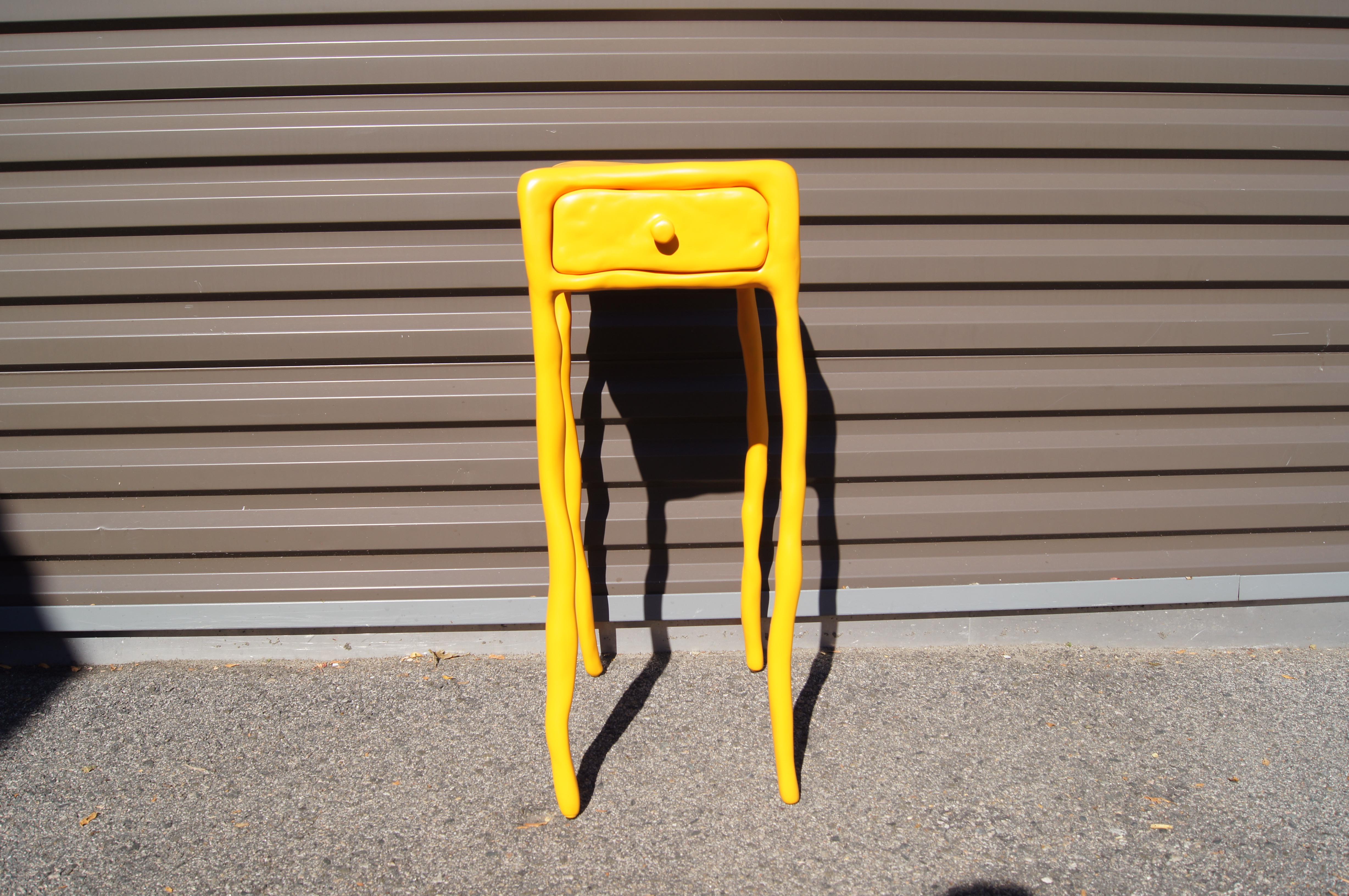 Created by Dutch designer Maarten Baas, this little side table with drawer is part of his playful series of furniture made of clay hand-shaped over a metal frame. This bright yellow-orange piece is signed underneath: Maarten Baas September '06.