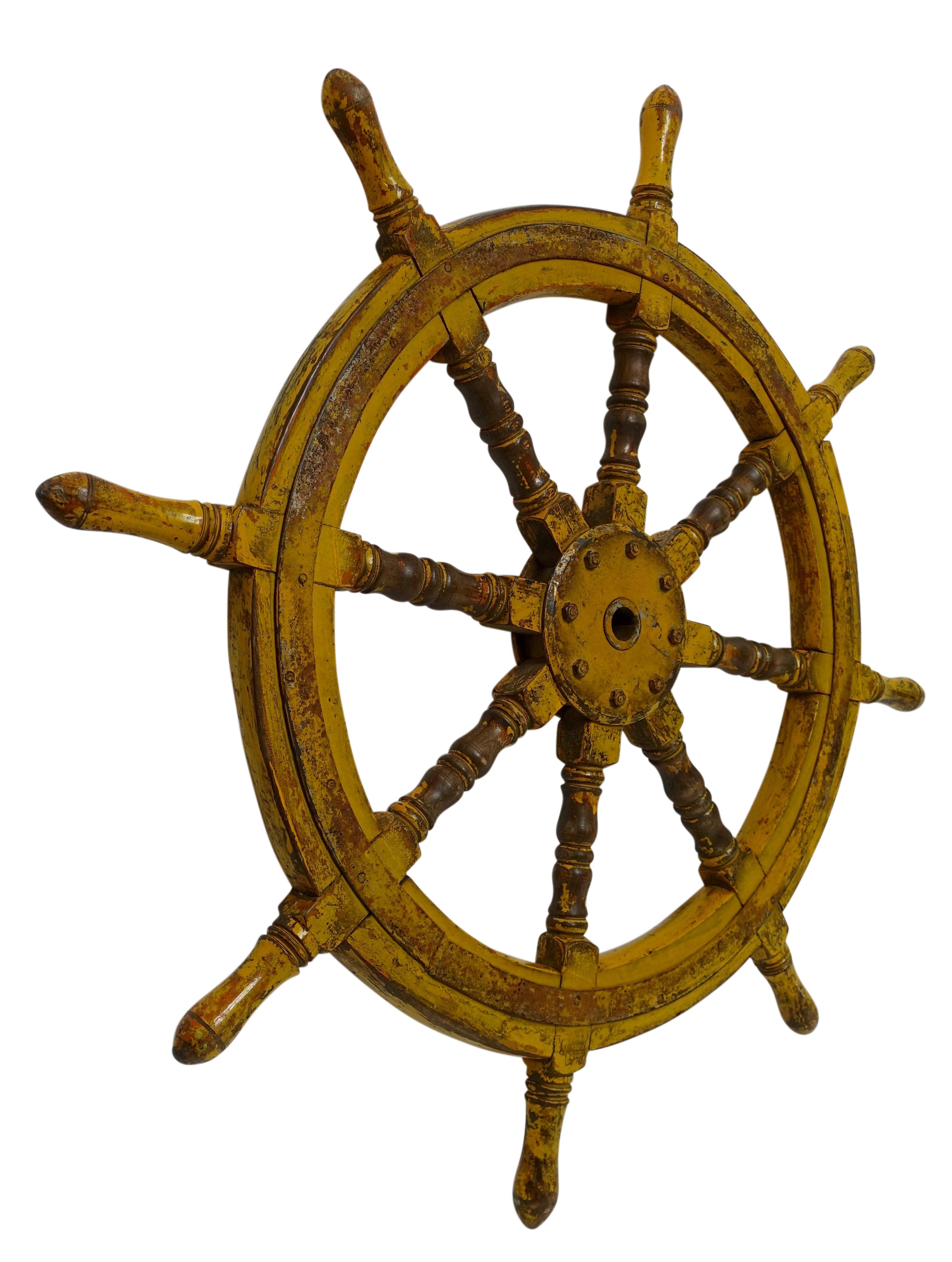 A walnut ships wheel with old yellow paint and wrought iron banding. Origin Unknown. Load of charm and character with a mix of the wood and iron and the wearing of the painted finish.