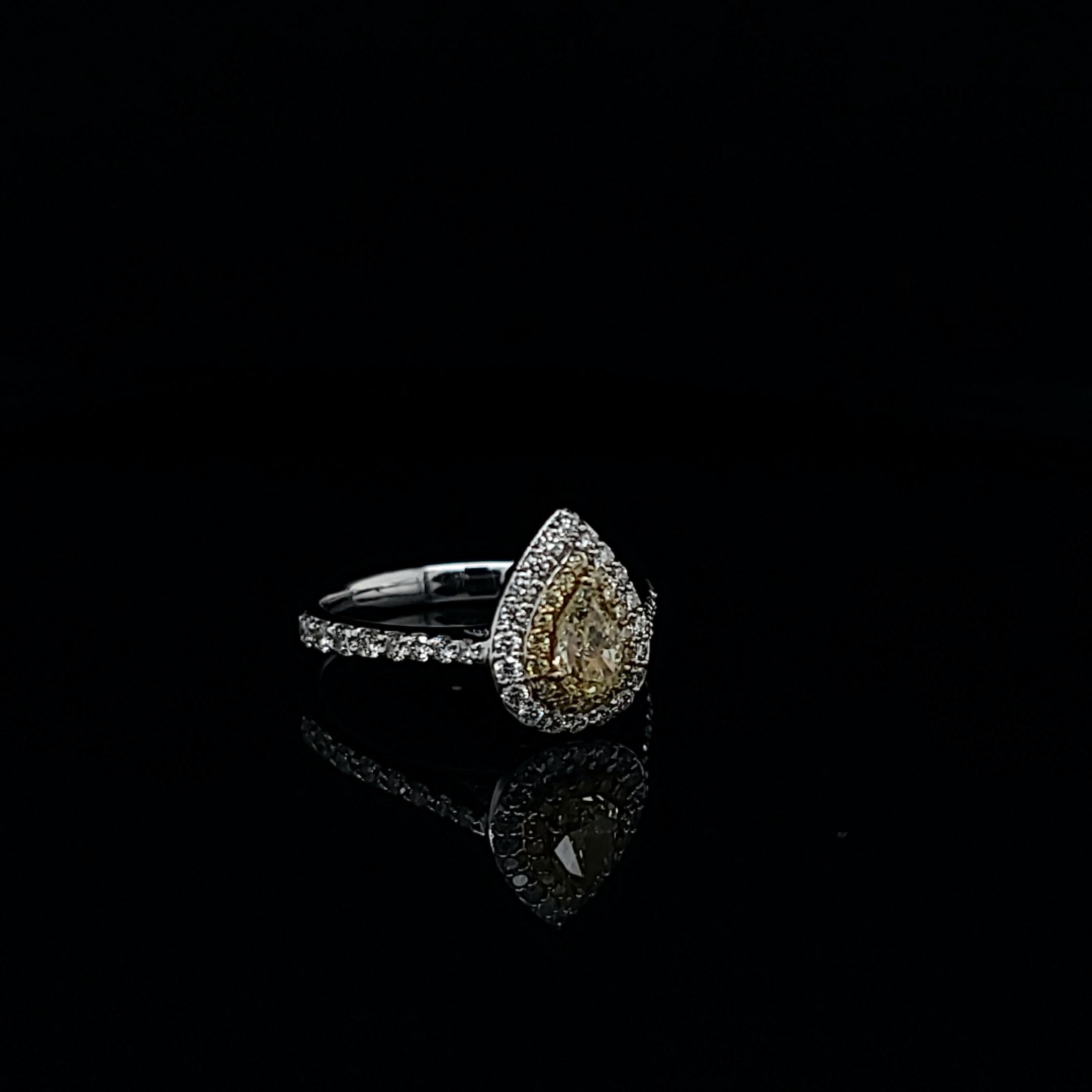 Yellow Pear Shape ring featuring a 0.43 fancy yellow diamonds. Accented by 16-0.09ctw yellow melee and 36-0.41ctw of white melee. Set in 18k white gold, size 6.5. Delivers LARGE look. Mounting that features double pave halo around center stone makes