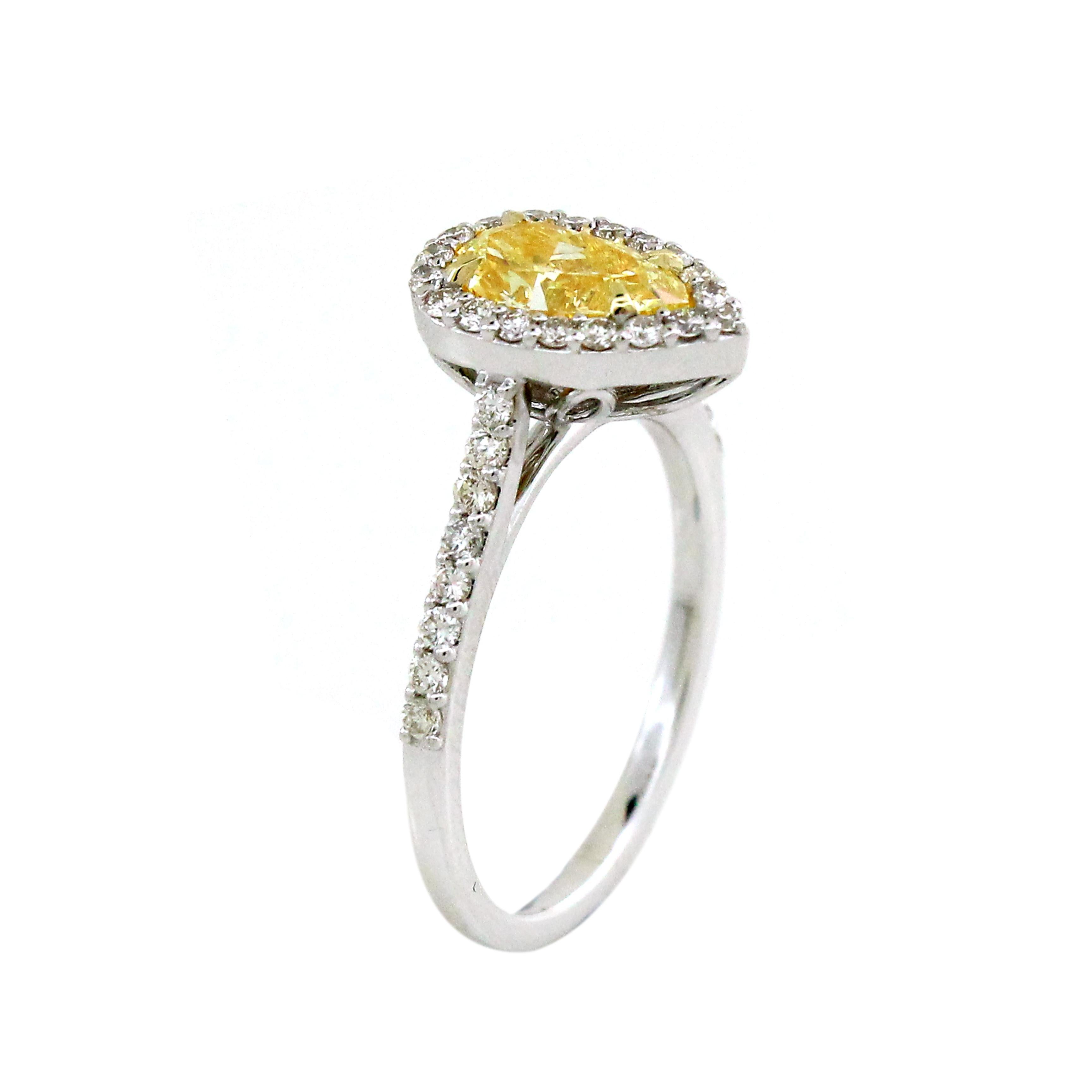 The star of this ring is the striking 1.02-carat yellow pear-cut diamond. Its unique and elegant shape, reminiscent of a teardrop, is perfectly complemented by its radiant yellow hue. Surrounding the yellow diamond are 35 white round diamonds,