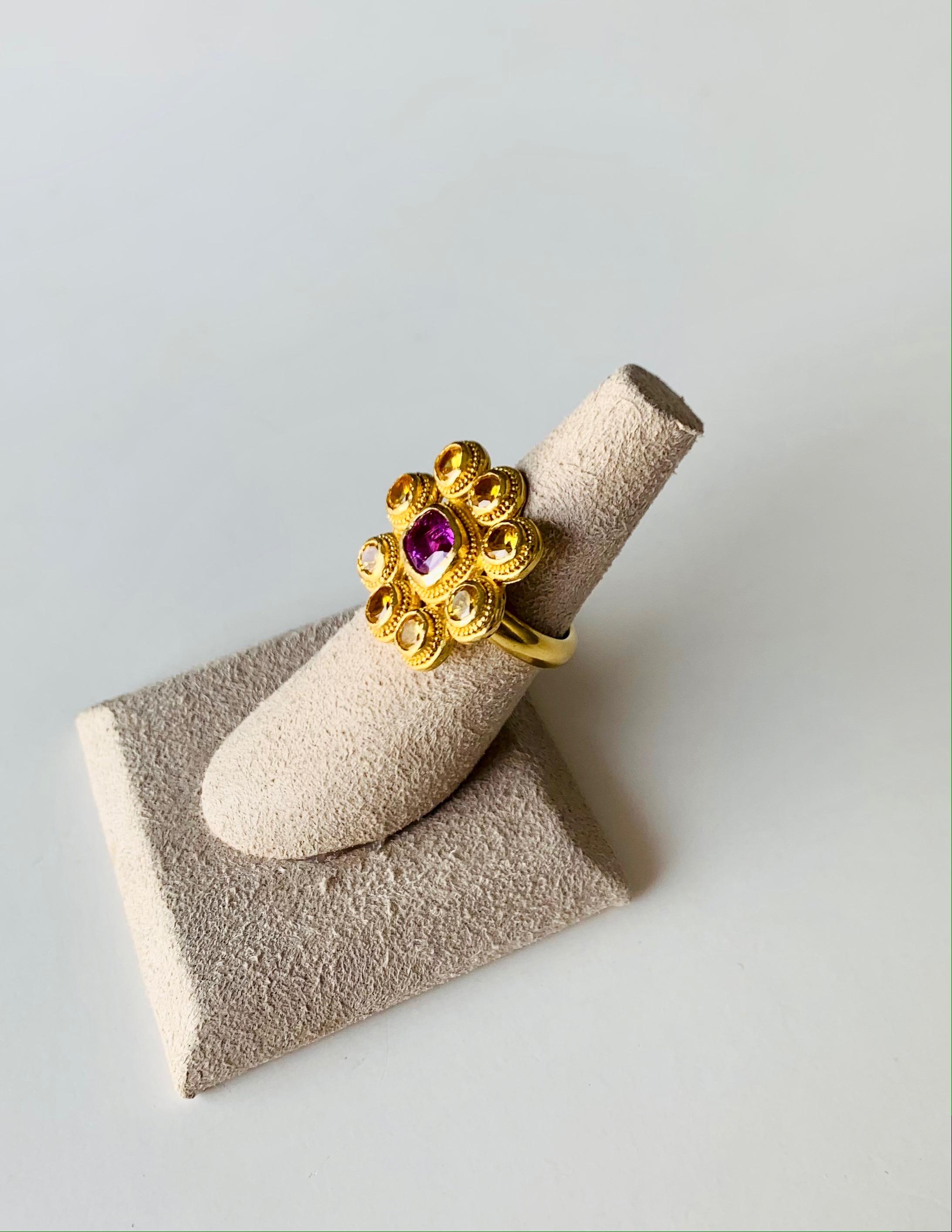 This brightly colored fancy yellow and pink Sapphire cocktail ring will add sparkle to any occasion and outfit .
the stones are set in 22 Karat gold with granulation detailing .
It is entirely handcrafted by the artist in her New York studio. Size