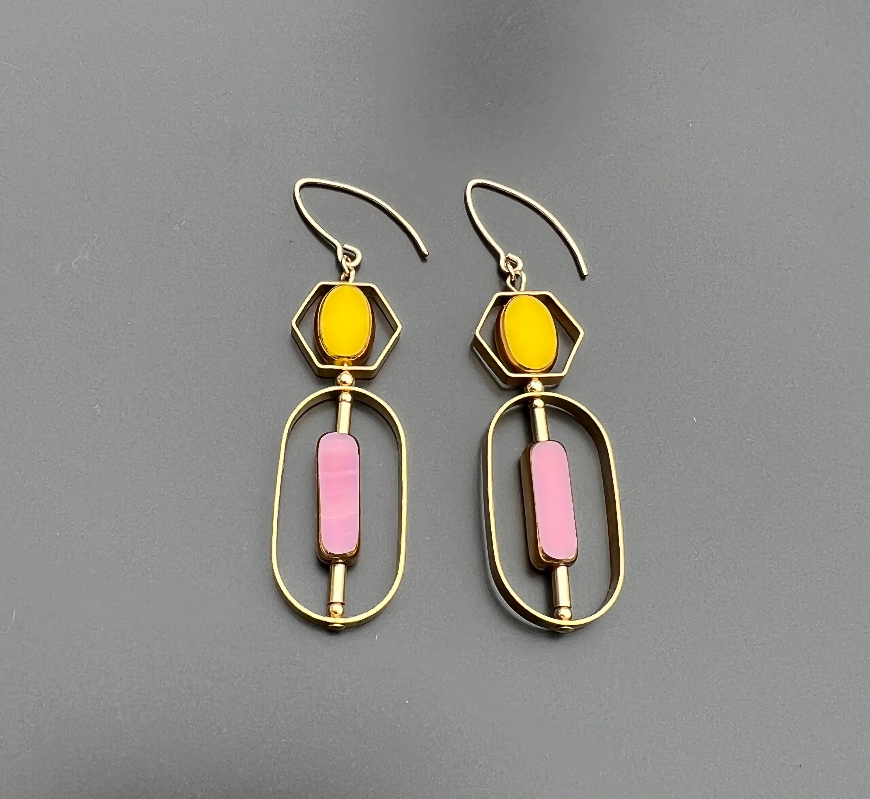 The earrings are light weight and are made to rotate and reposition with movement.

The earrings consist of a yellow oval and pink long rectangular shaped beads. They are new old stock vintage German glass beads that are framed with 24K gold. The
