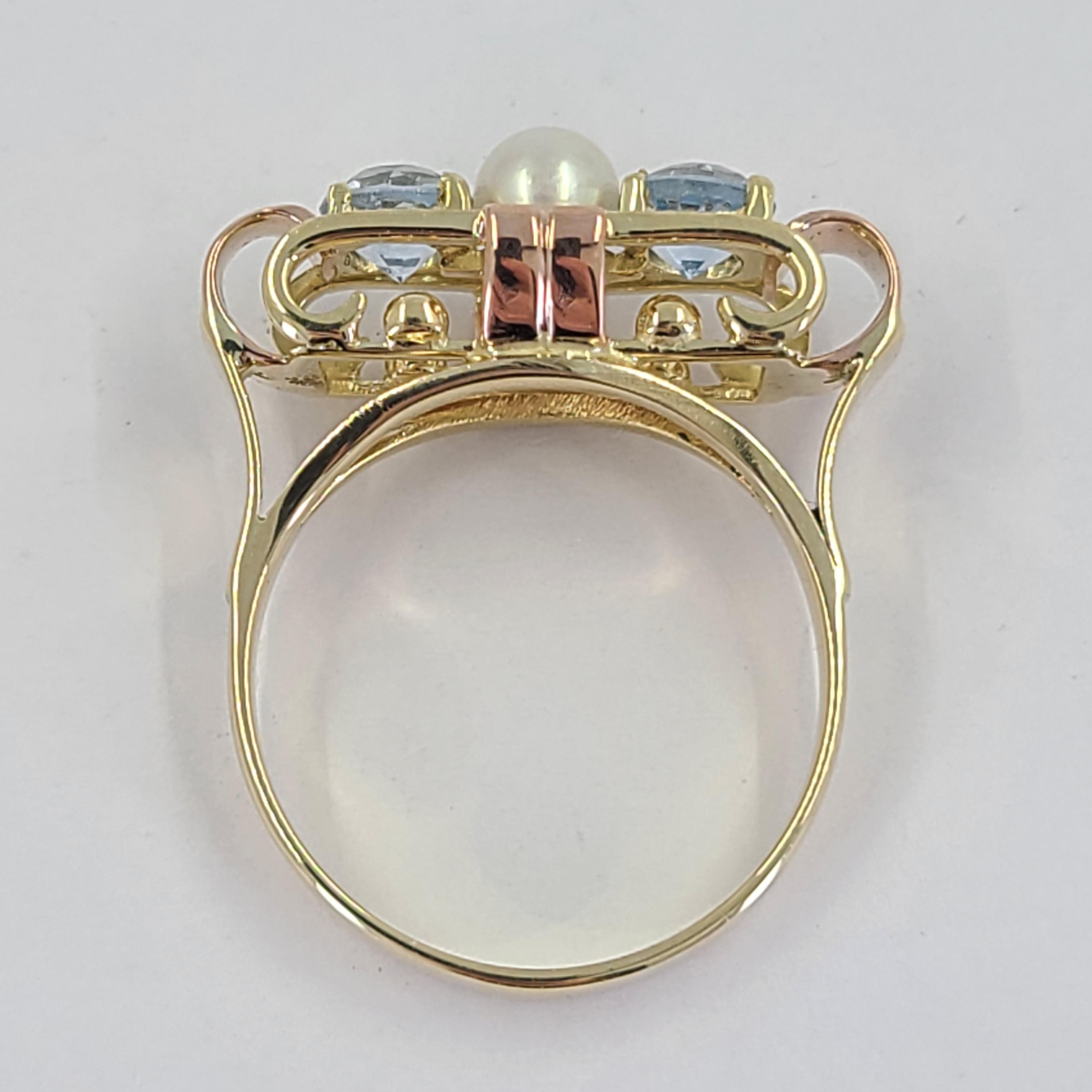 14 Karat Yellow & Rose Gold Retro Ring With Open Work Design Featuring A Round 4mm Cultured Pearl & Two 4.5mm Round Aquamarines. Finished Weight Is 4.3 Grams. Finger Size 6.