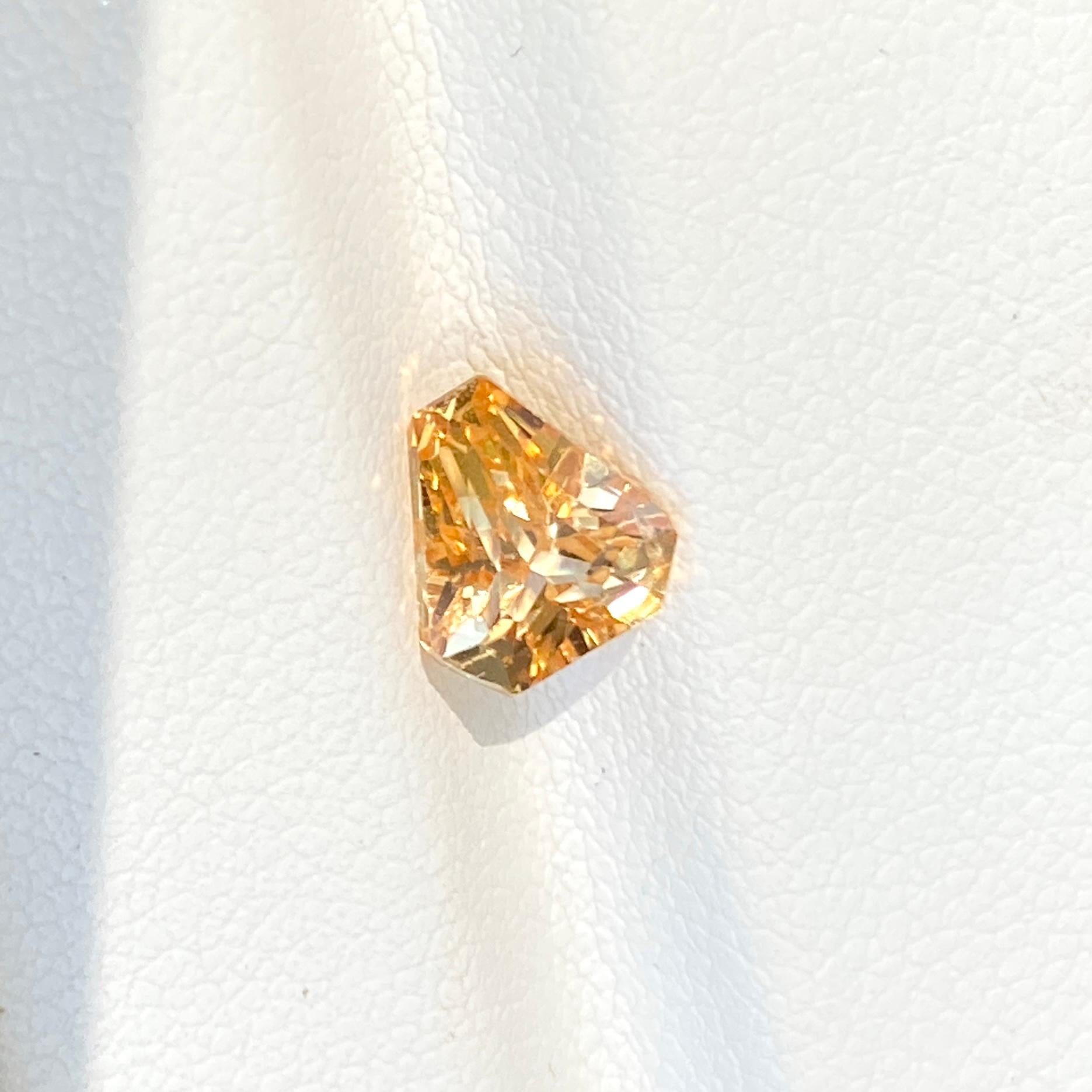 Over 1 carat this extraordinary individual shield cut natural Sri Lankan yellow sapphire has an enhanced glowing rosy gold appearance. A unique triangular fancy cut for that alternative bespoke jewellery piece.

This yellow sapphire is available to