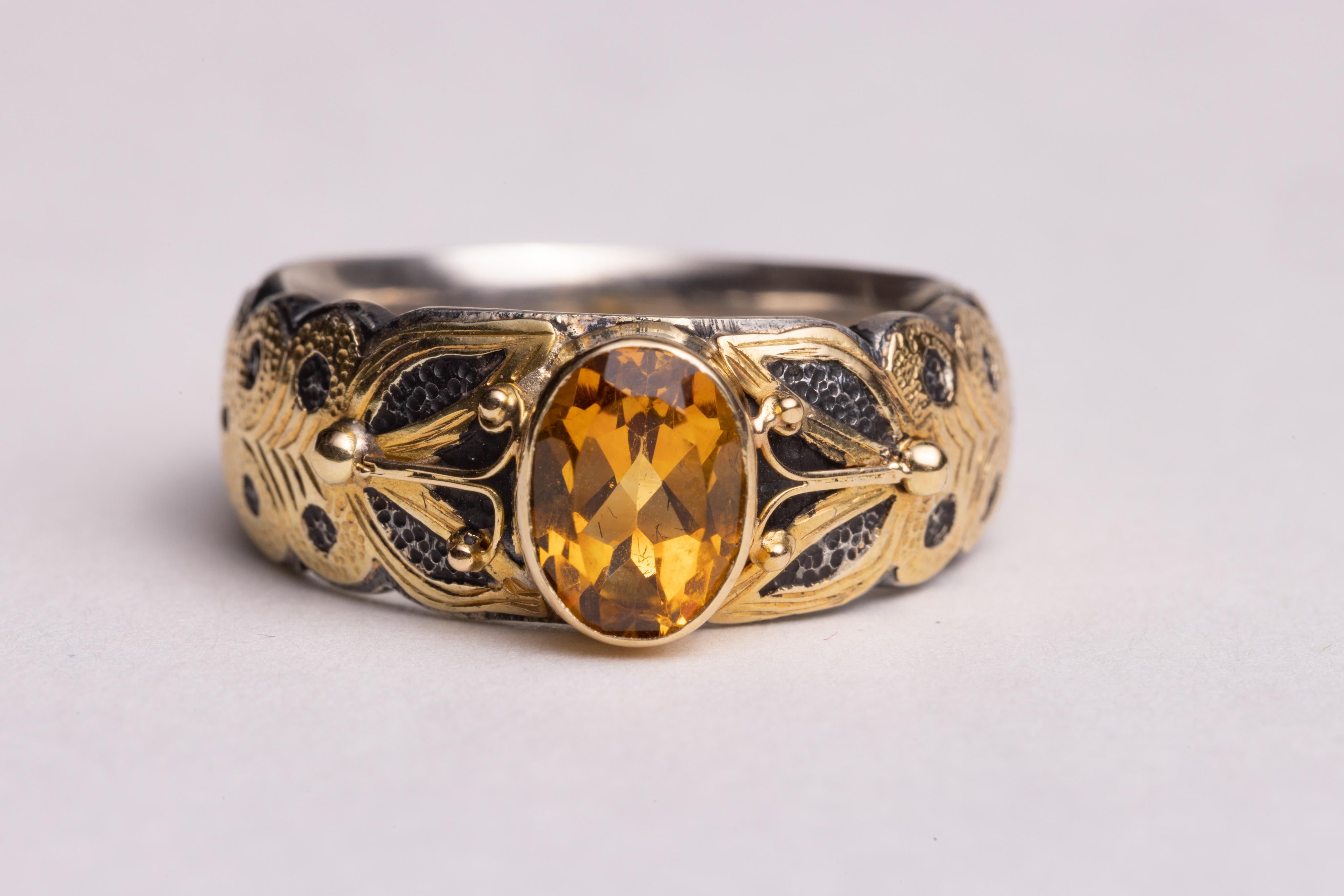 A stunning faceted, oval yellow sapphire ring with sterling silver with a hand-tooled 18K gold overlay.  Ring size is 7.25.  Probably easier to size down than up, but not impossible.
