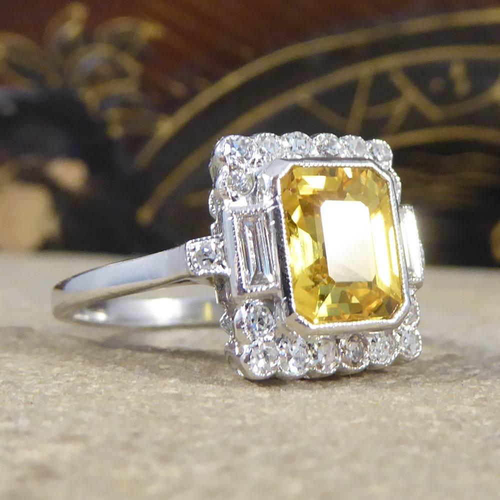 This gorgeous 1.90ct emerald cut yellow Sapphire is surrounded by 16 brilliant cut diamonds and two baguette diamonds weighing 0.30ct in total. Although this is a new contemporary ring it has been crafted to resemble a beautiful Art Deco style in