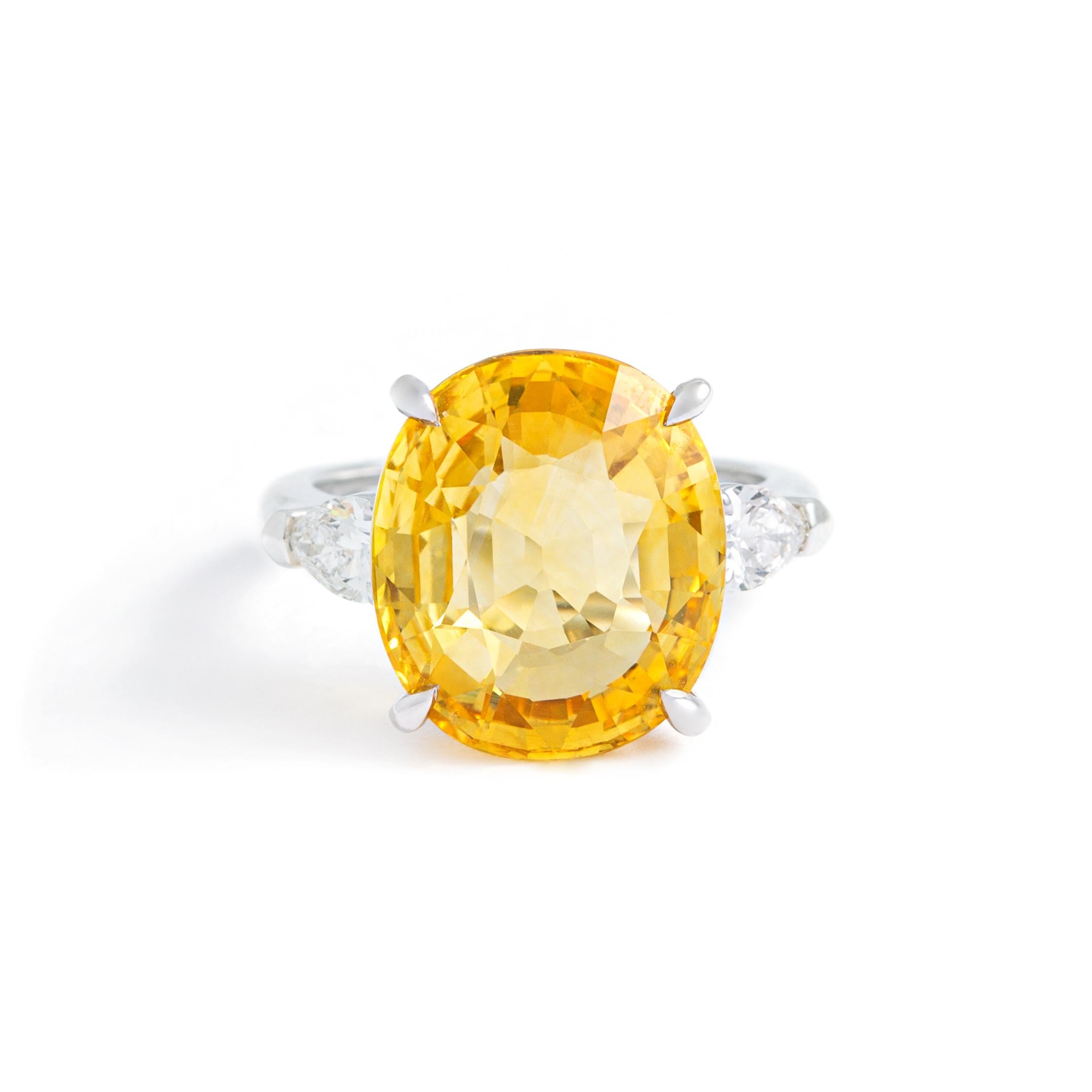 Yellow Sapphire (heated) shouldered by pear shape Diamonds on white gold Ring.