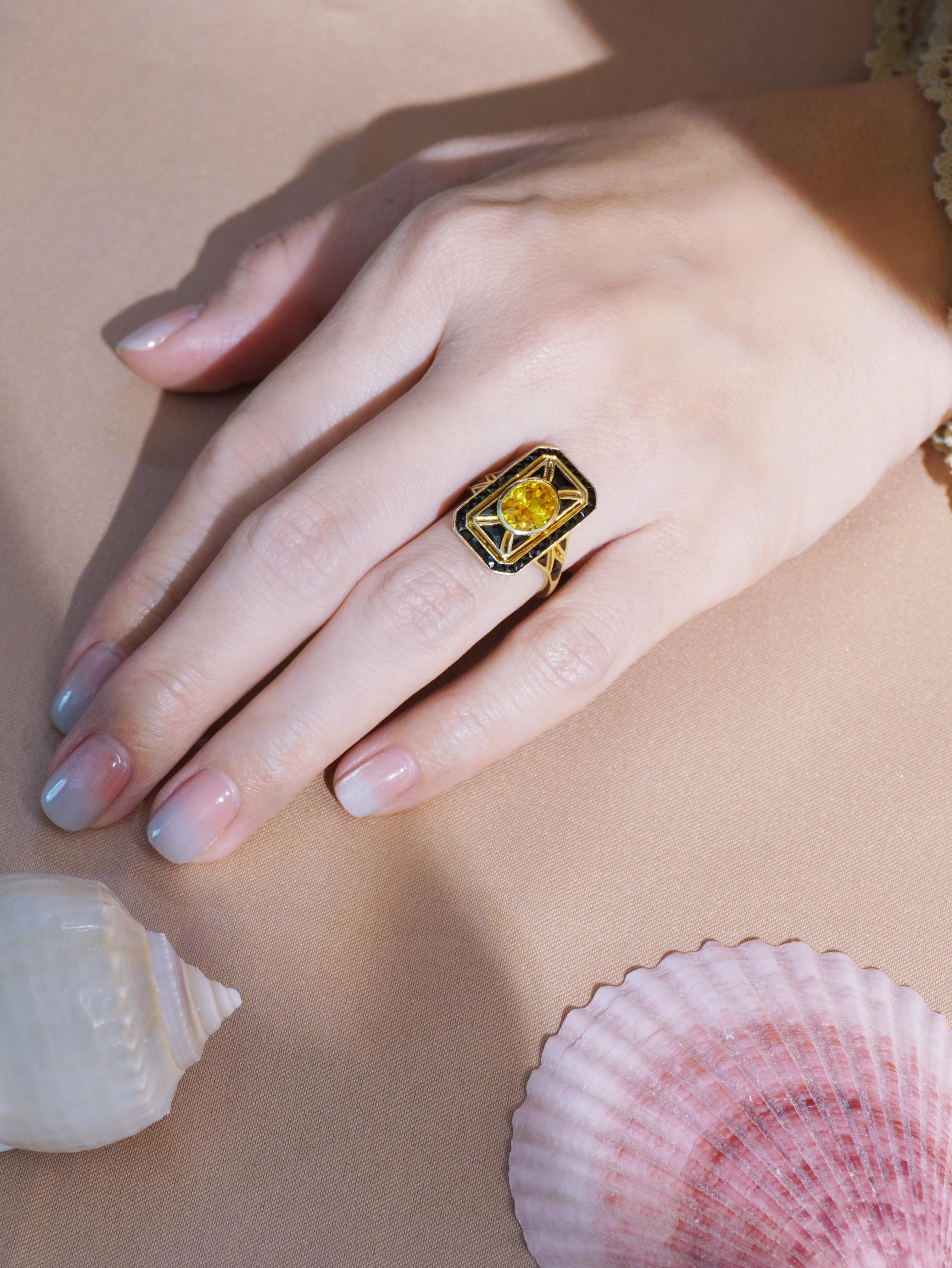 A vibrant oval shaped yellow sapphire at the center, surrounded by bold onyx accents. The geometric design and striking contrast between the bright yellow of the sapphire and the deep black onyx capture the essence of Art Deco elegance. A timeless,