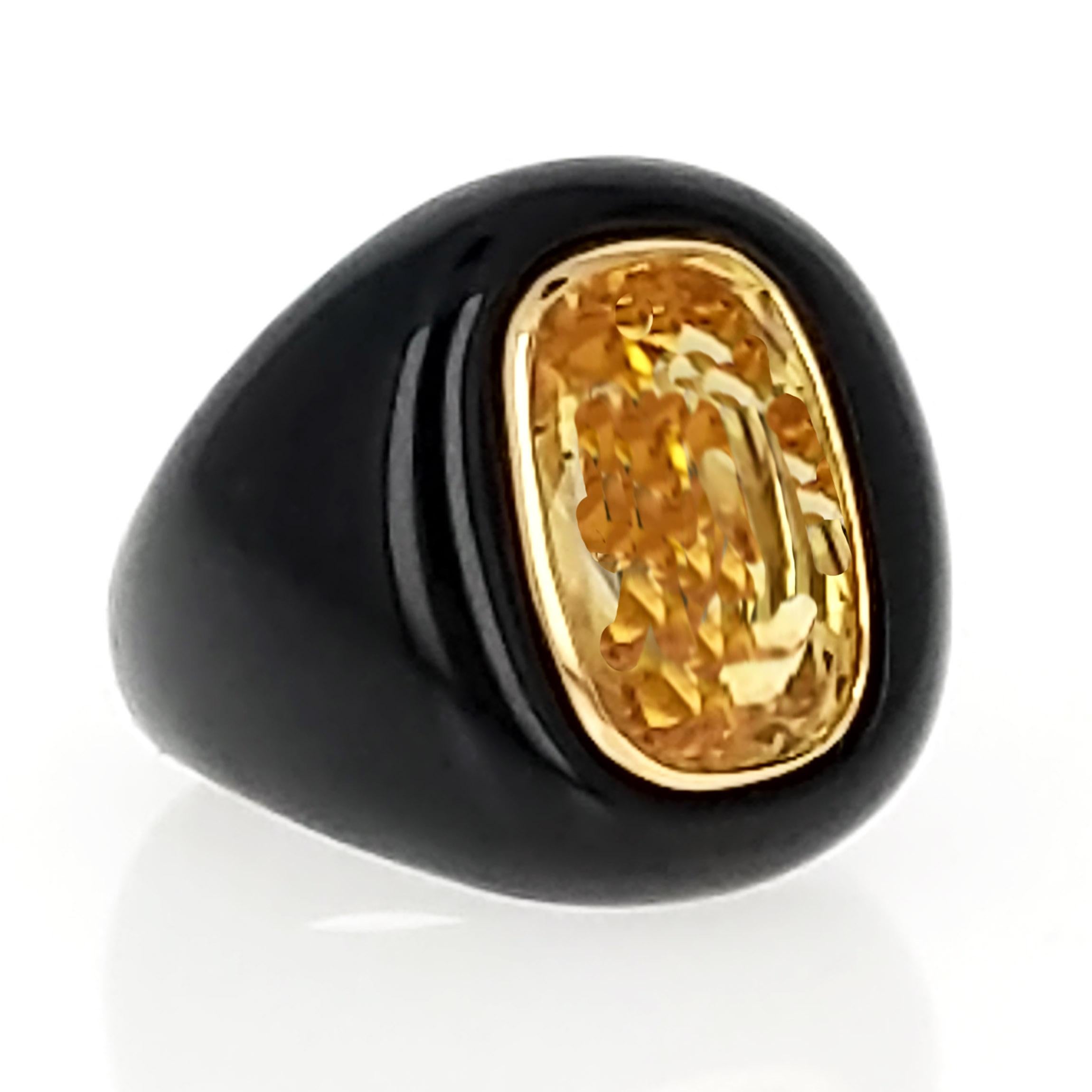The ring is set with a cushion-cut yellow sapphire of 14.10 carats. The sapphire is bezel set with 18 karat yellow gold and mounted in carved black jade. It is size 6 1/2. This is a very comfortable ring with a chic and dramatic look. 

It is