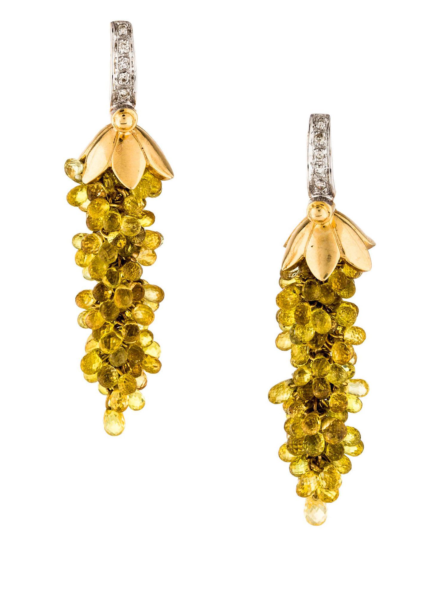 A beautiful pair of chandelier earrings with yellow sapphires held together by a golden flower cap, accented with diamonds on the top in 14K Gold (Yellow and White). Length: 1 3/4