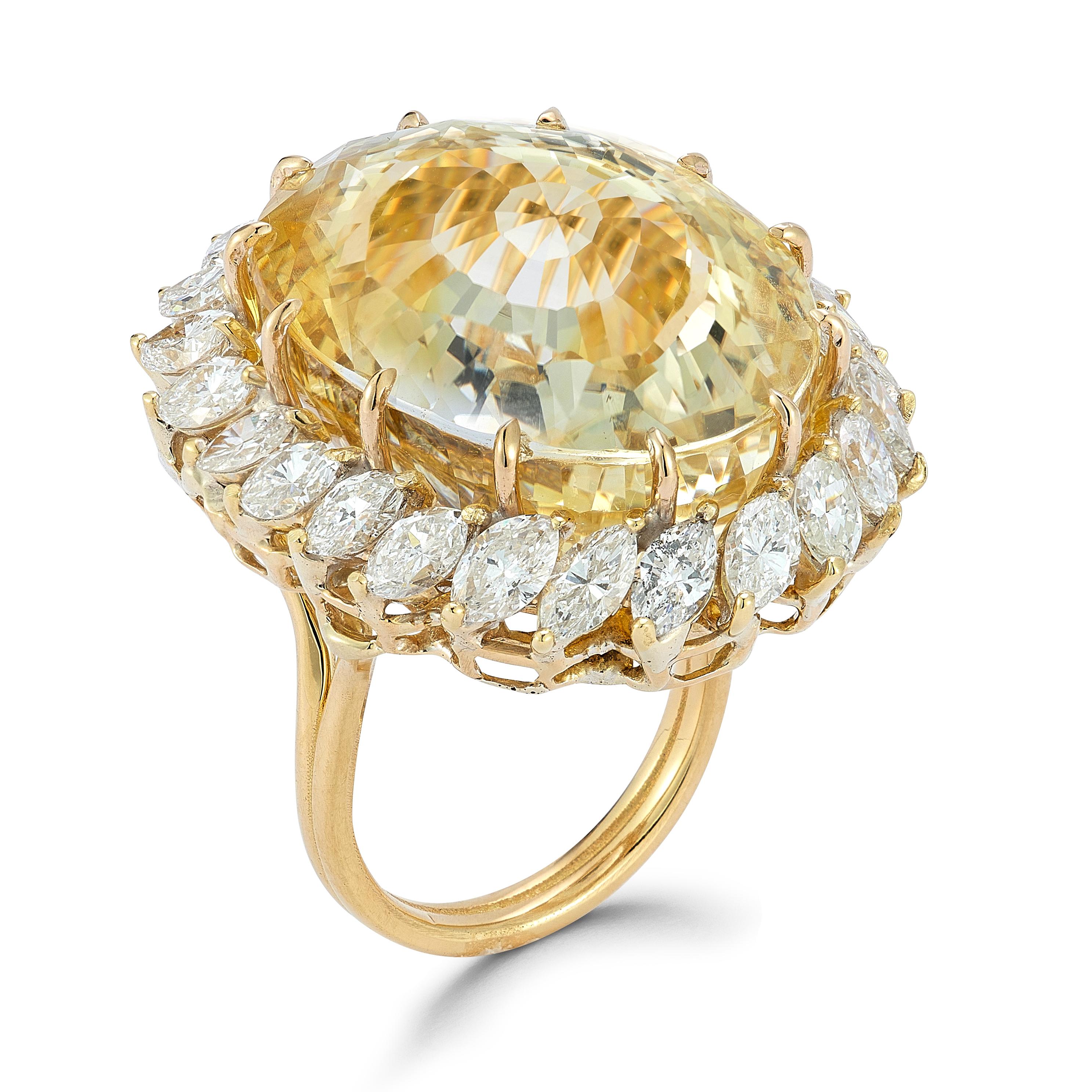 Yellow Sapphire Cocktail Ring 

A cocktail ring with a large oval yellow sapphire surrounded with 24 marquise cut diamonds. 

Approximate Sapphire Weight: 71.91 carats  
Approximate Diamond Weight: 3.67 carats
Ring size: 6 
Resizable free of