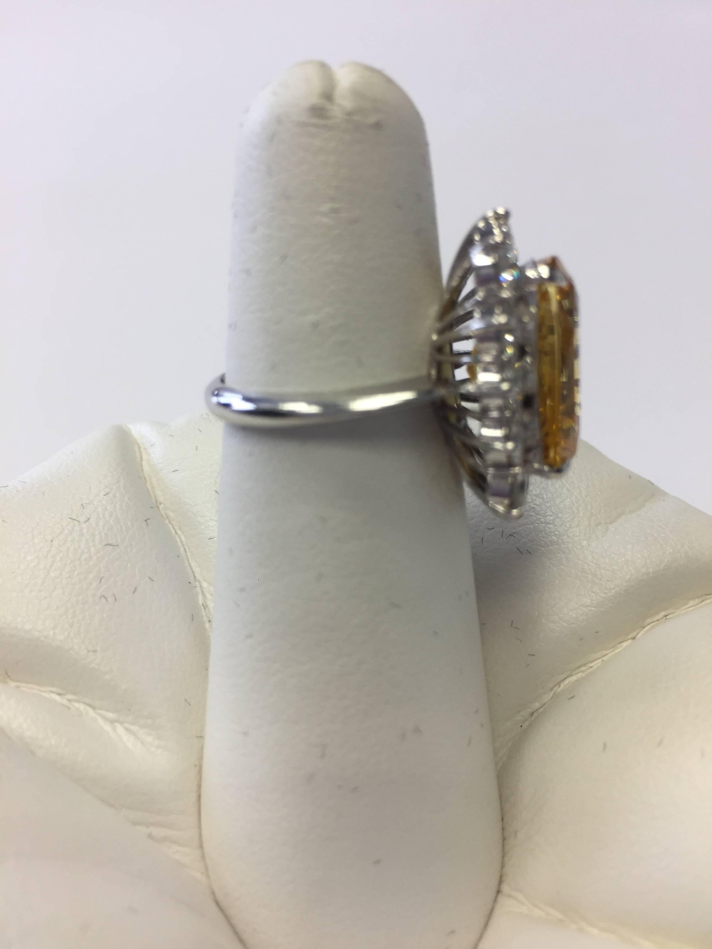 Bright canary yellow sapphire cushion surrounded with white diamonds in a delicate 18k yellow gold mounting.  AGL Certified. Size 5.5.