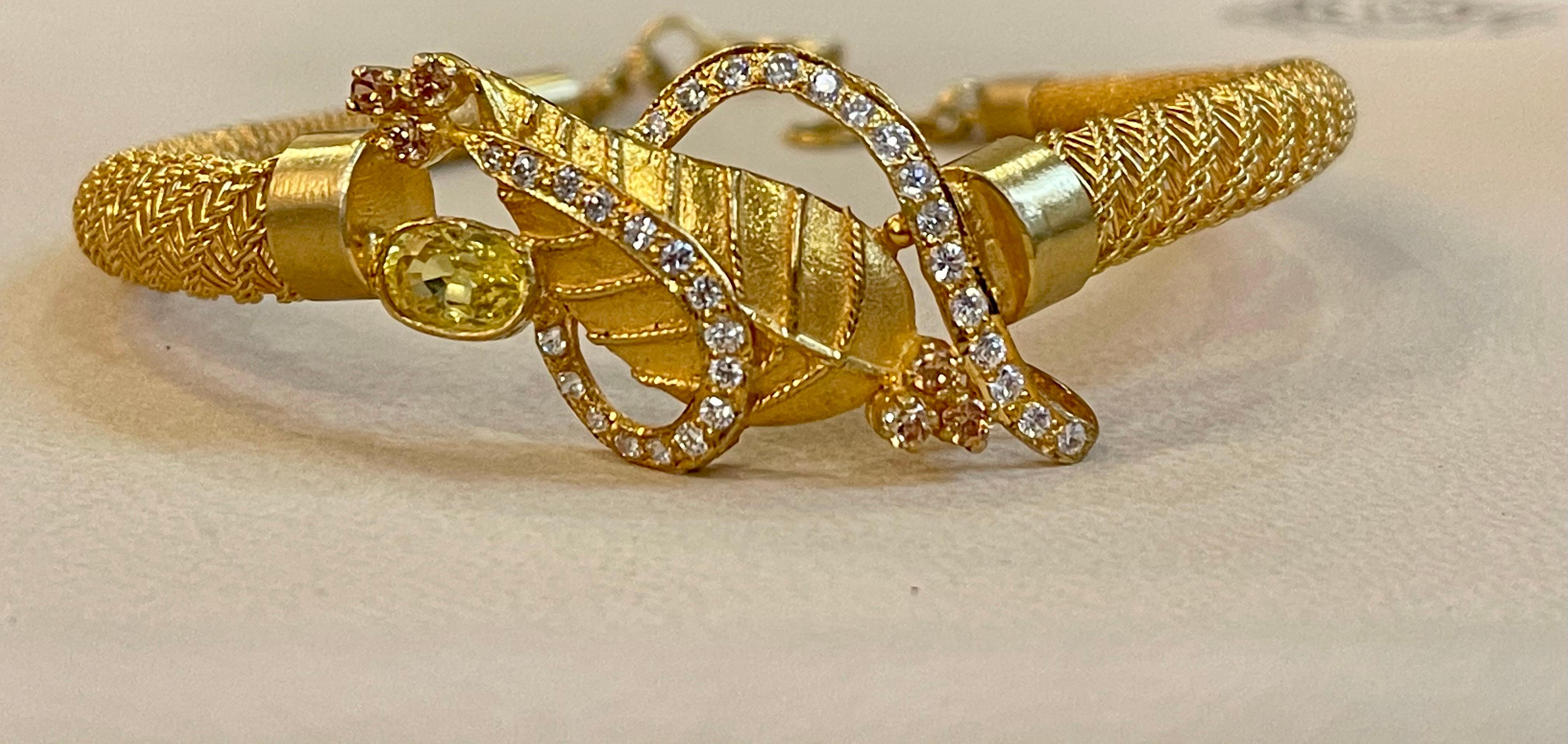 Yellow Sapphire & Diamond Bangle or Bracelet in 22 Karat Yellow Gold 20.8 Grams
It features a bangle style  Bracelet crafted from 22 Karat  Yellow gold and embedded with Oval Yellow Sapphire  weighting approximately 1 Carat
 There are Round diamonds