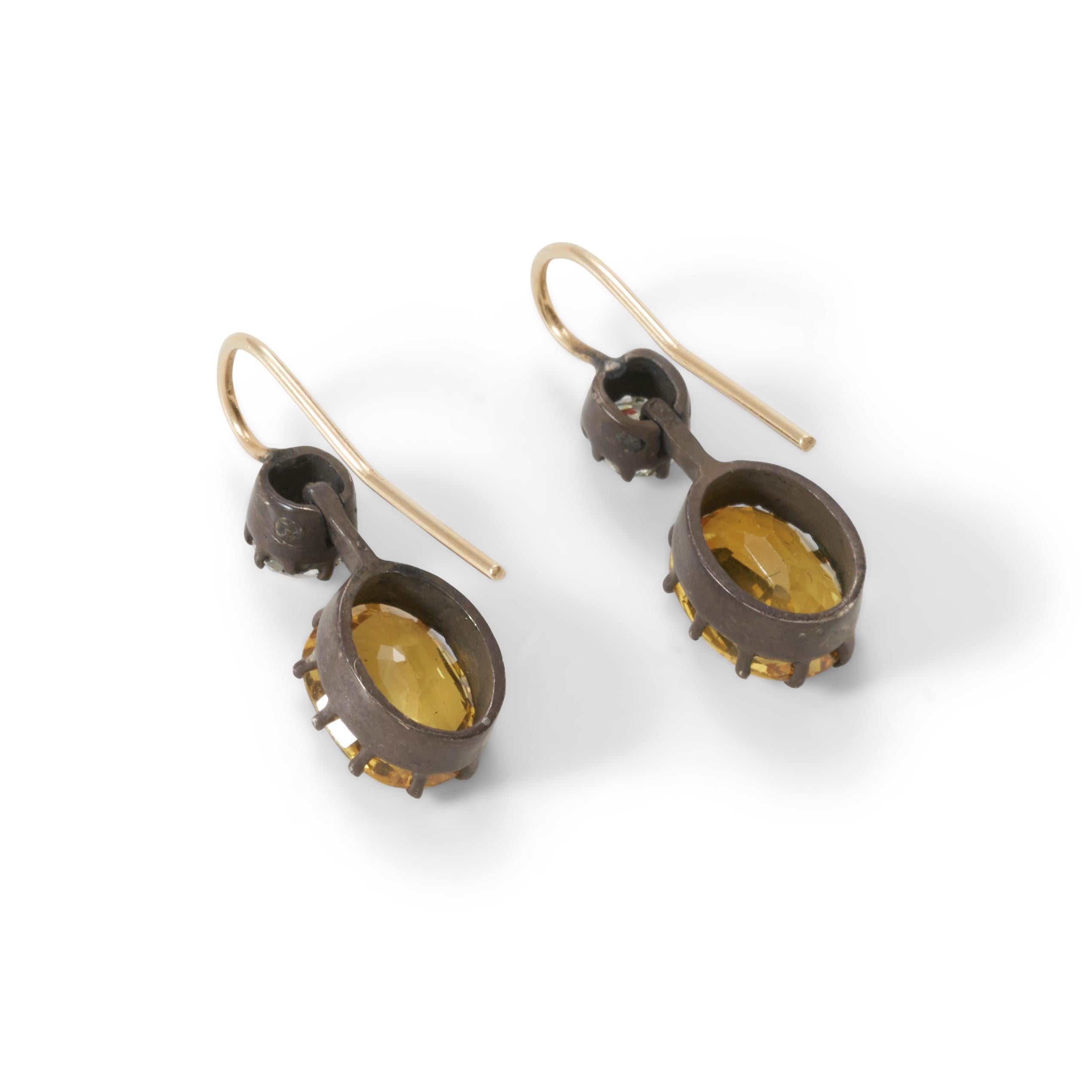 Ces délicates boucles d'oreilles présentent des saphirs jaunes ovales sertis en chaton, pesant environ 5-6 ct, surmontés de diamants taillés dans des mines anciennes, pesant environ 0,70 ct.