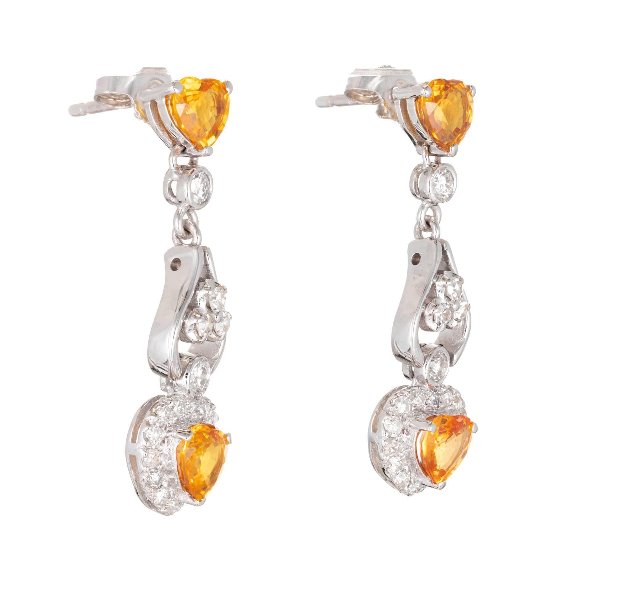 Yellow heart shaped sapphires with diamond halo dangle earrings. 14k white gold dangle earrings with bright yellow Sapphires and bright white diamonds.

4 bright yellow heart Sapphires, approx. total weight 1.11cts, natural and no heat treatment
6