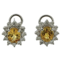 Clous d'oreilles en platine avec saphir jaune et halo de diamants