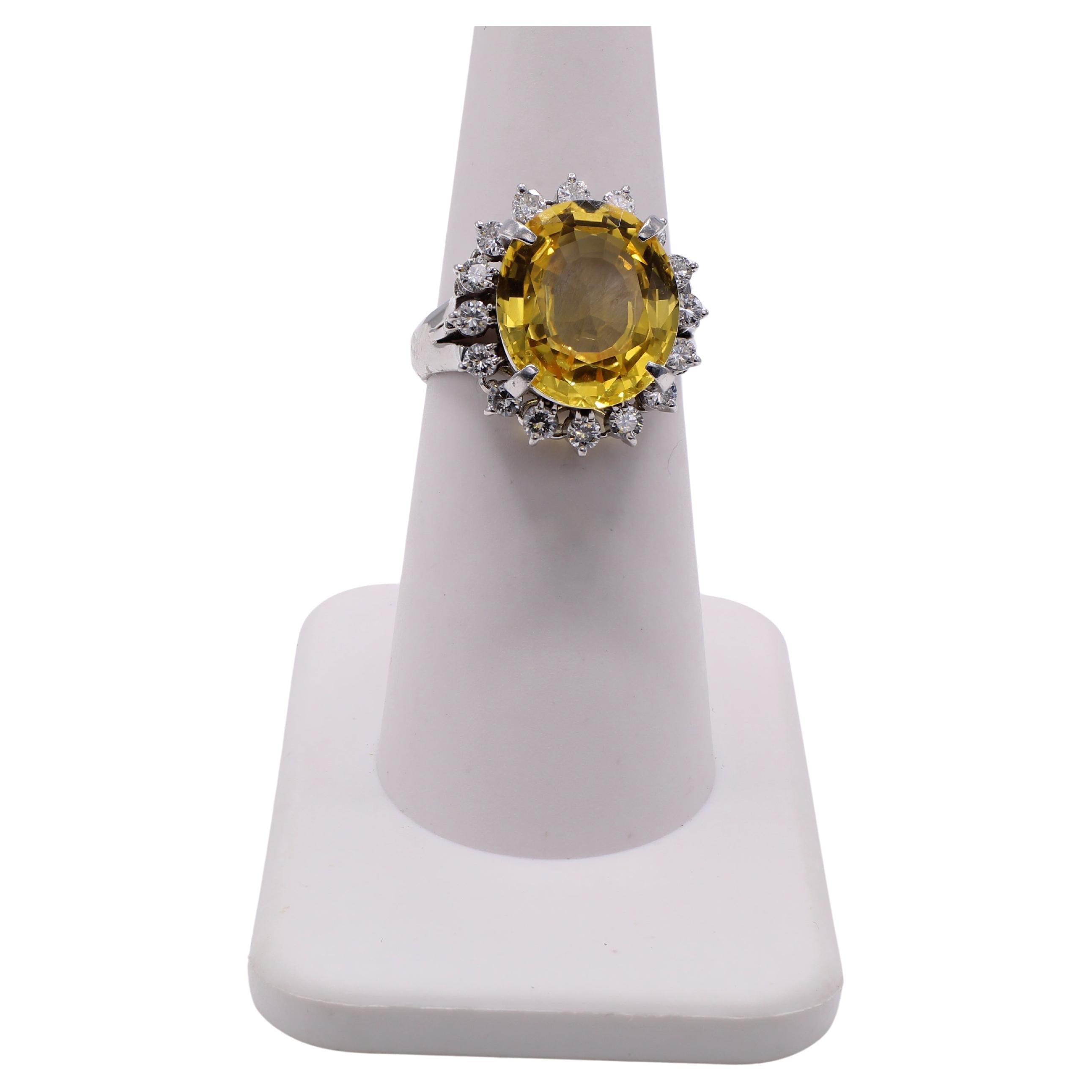 The center piece of this 1970s cocktail ring is a gorgeous deep saturated yellow sapphire weighing 6.66 carats. The center gem is surrounded by 16 bright white sparkly round brilliant cut diamonds weighing 0.62 carats - weights are stamped on inside
