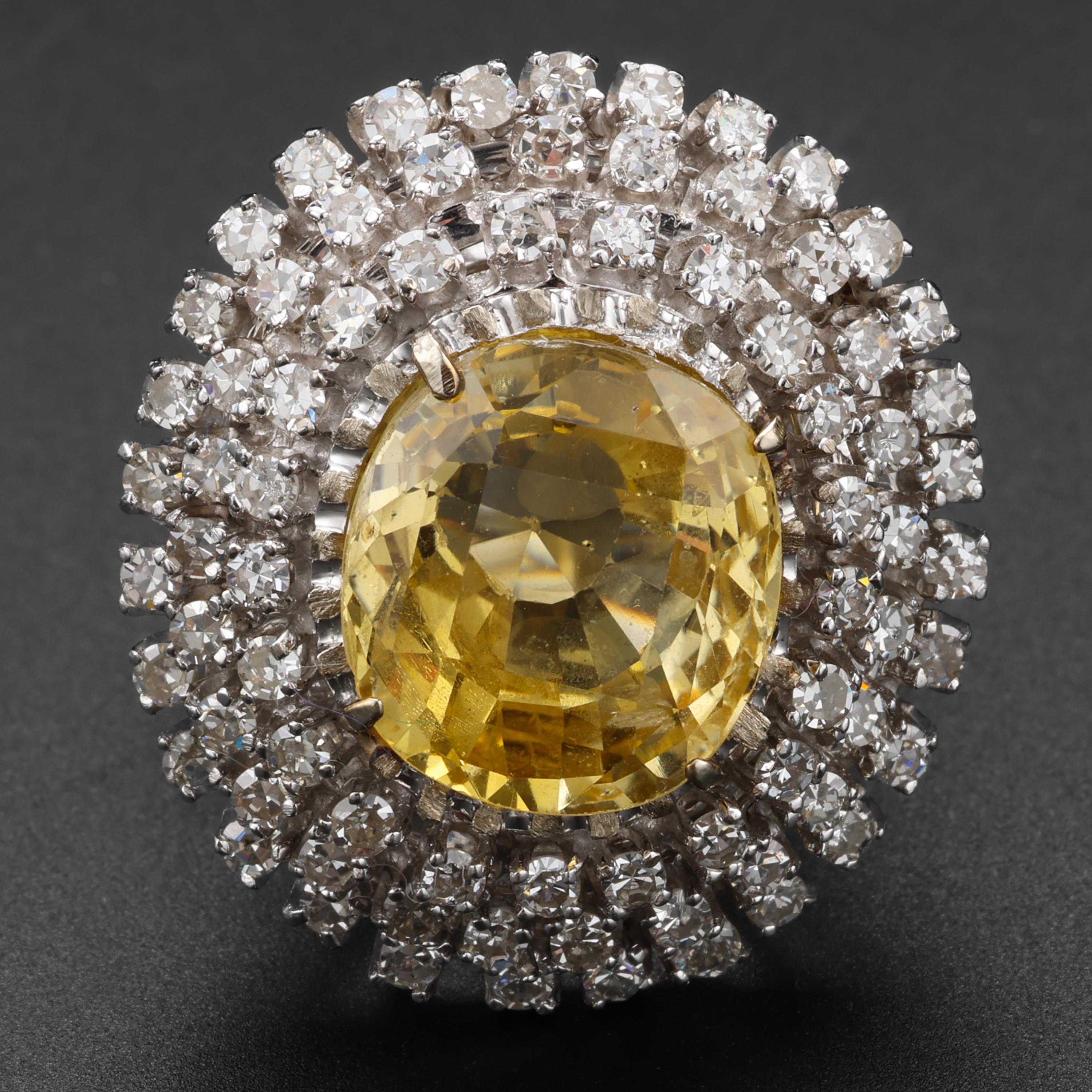 Un saphir jaune canari absolument magnifique, pesant 12,5 carats, est entouré de trois halos de diamants flamboyants pour une bague Retro d'une beauté hypnotique. Les 75 diamants blancs, d'une pureté irréprochable, pèsent au total environ 1,5