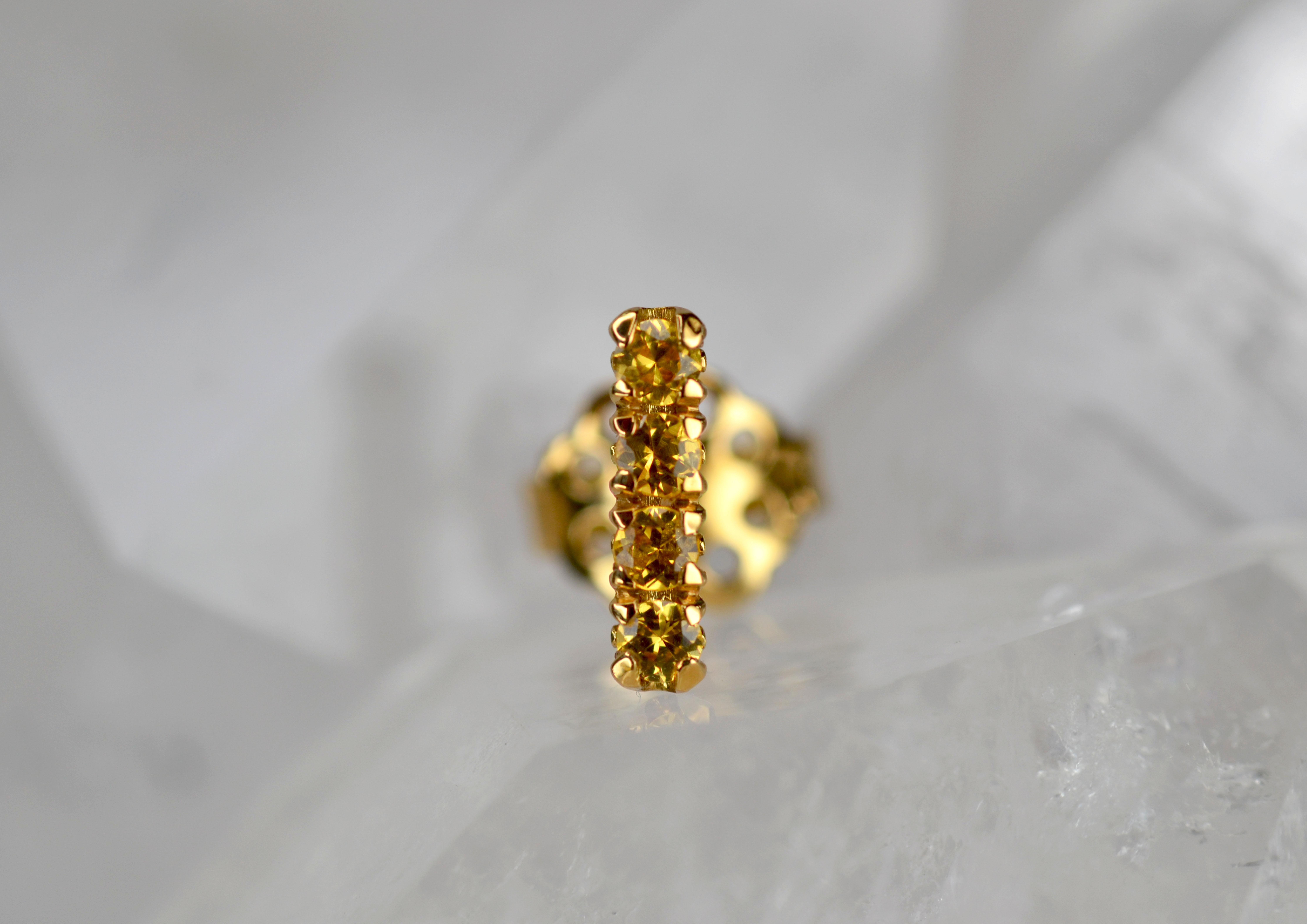 This single earring stud is part of our Blossom Collection of mix and match pieces. The glistening yellow sapphires are set on an 18k gold blossom flower collet to be worn alongside your favourite pair of earrings, our blossom hoops, or combine with