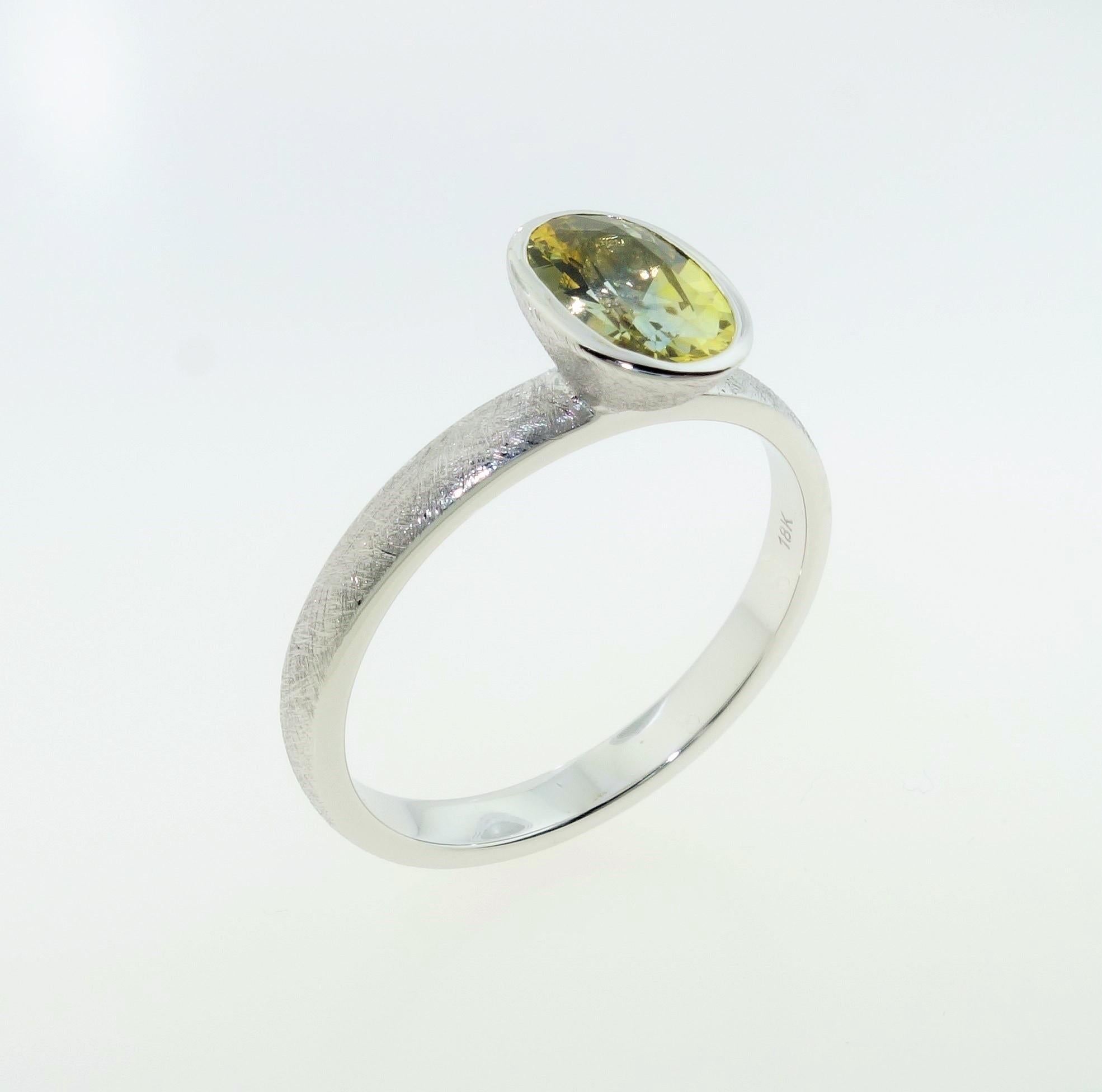 Simply Beautiful, Elegant and finely detailed Stacking Ring, set with an oval Yellow Sapphire, weighing approx. 1.03 Carats and measuring 8.0mm x 5.1mm. Hand crafted and Hand Textured in 18 Karat Yellow Gold. Ring size 8; we offer ring re-sizing.