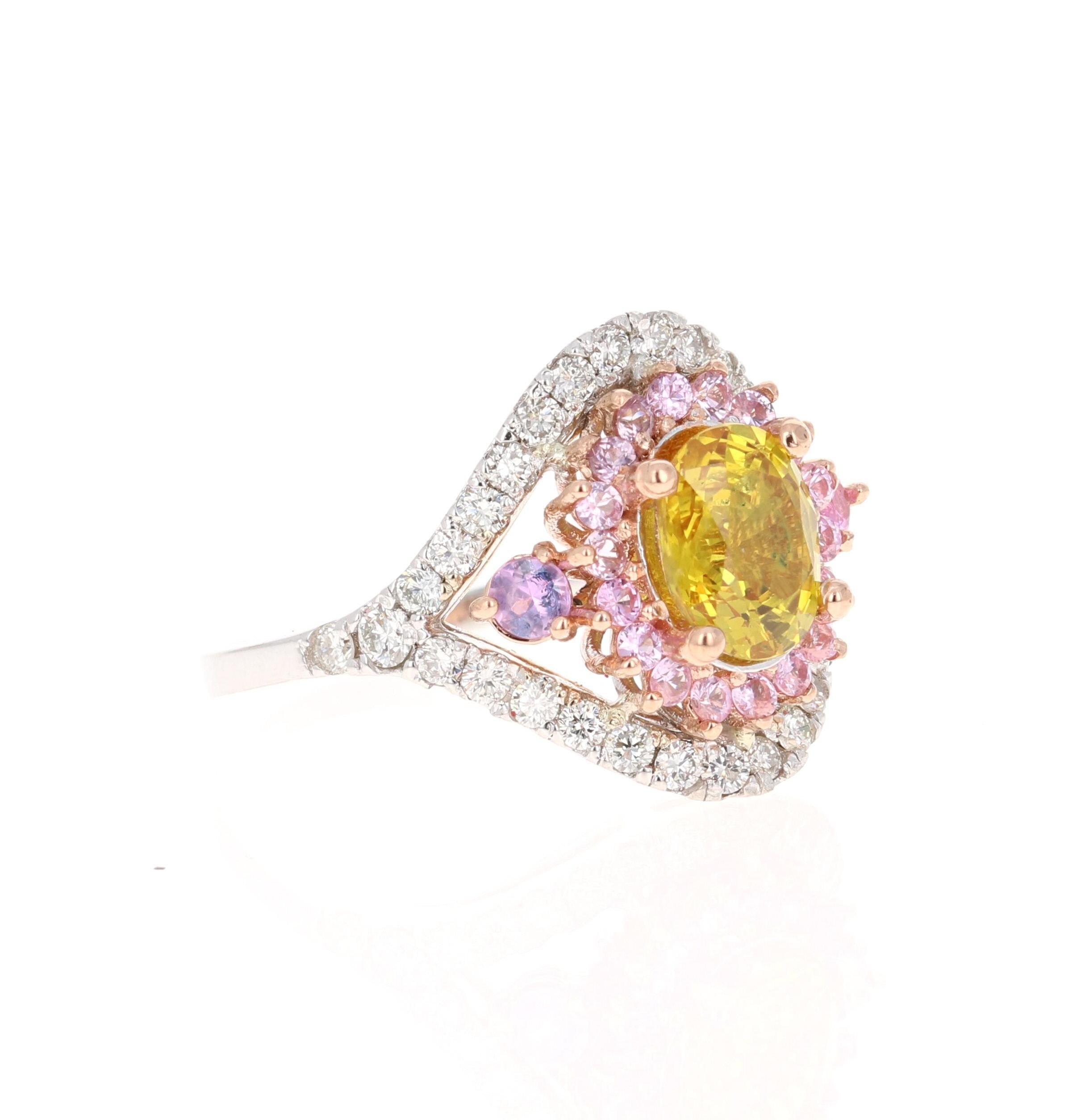 This beautiful ring has an Oval Cut Yellow Sapphire that weighs 1.66 Carats. It is surrounded by 21 Round Cut Pink Sapphires that weigh 0.57 Carats and 36 Round Cut Diamonds that weigh 0.70 Carats. (Clarity: VS, Color: H) The total carat weight of