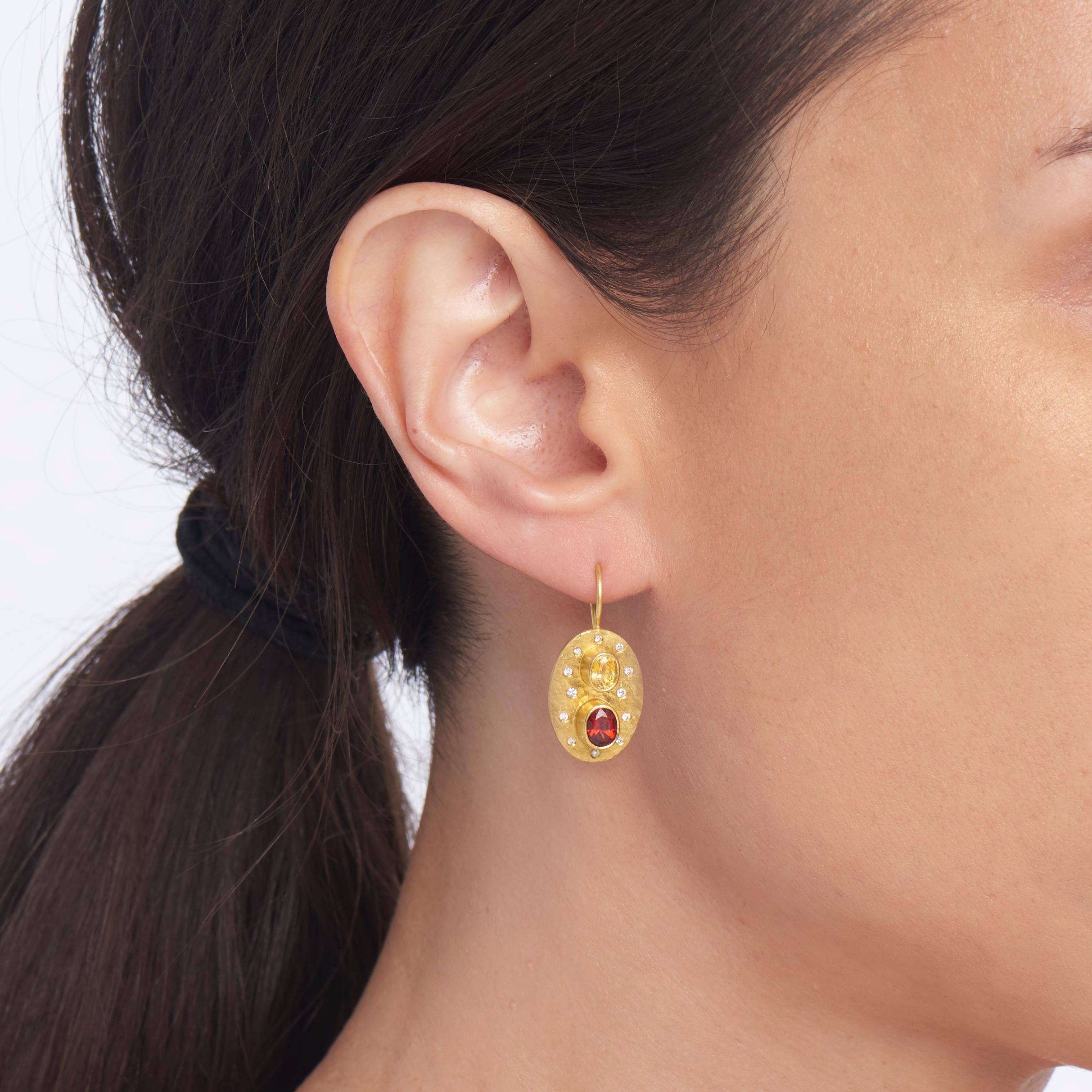 Add a honeyed yellow sapphire (1.38 carats), a luscious red spinel (1.98 carats), bright, clean white diamonds (1.2 total carat weight) to a hammered oval back sheet of 22 karat yellow gold, and you have a sensational pair of earrings.  The 18 karat