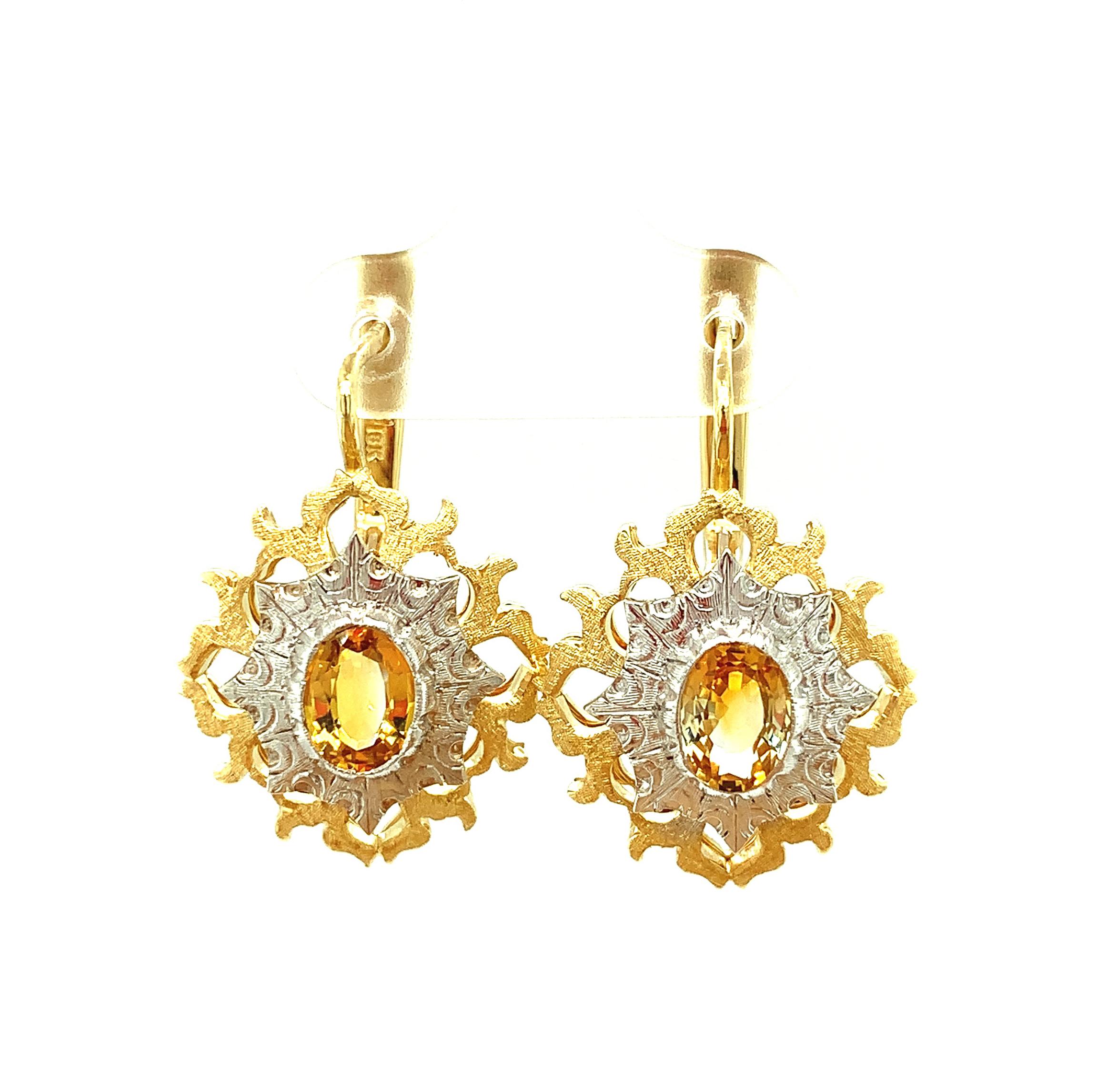 These beautifully original, handmade earrings are a lovely marriage of 18 karat yellow and white gold designed around a striking pair of bright yellow sapphires. Exquisitely engraved and finished, with just enough movement to give you that look of