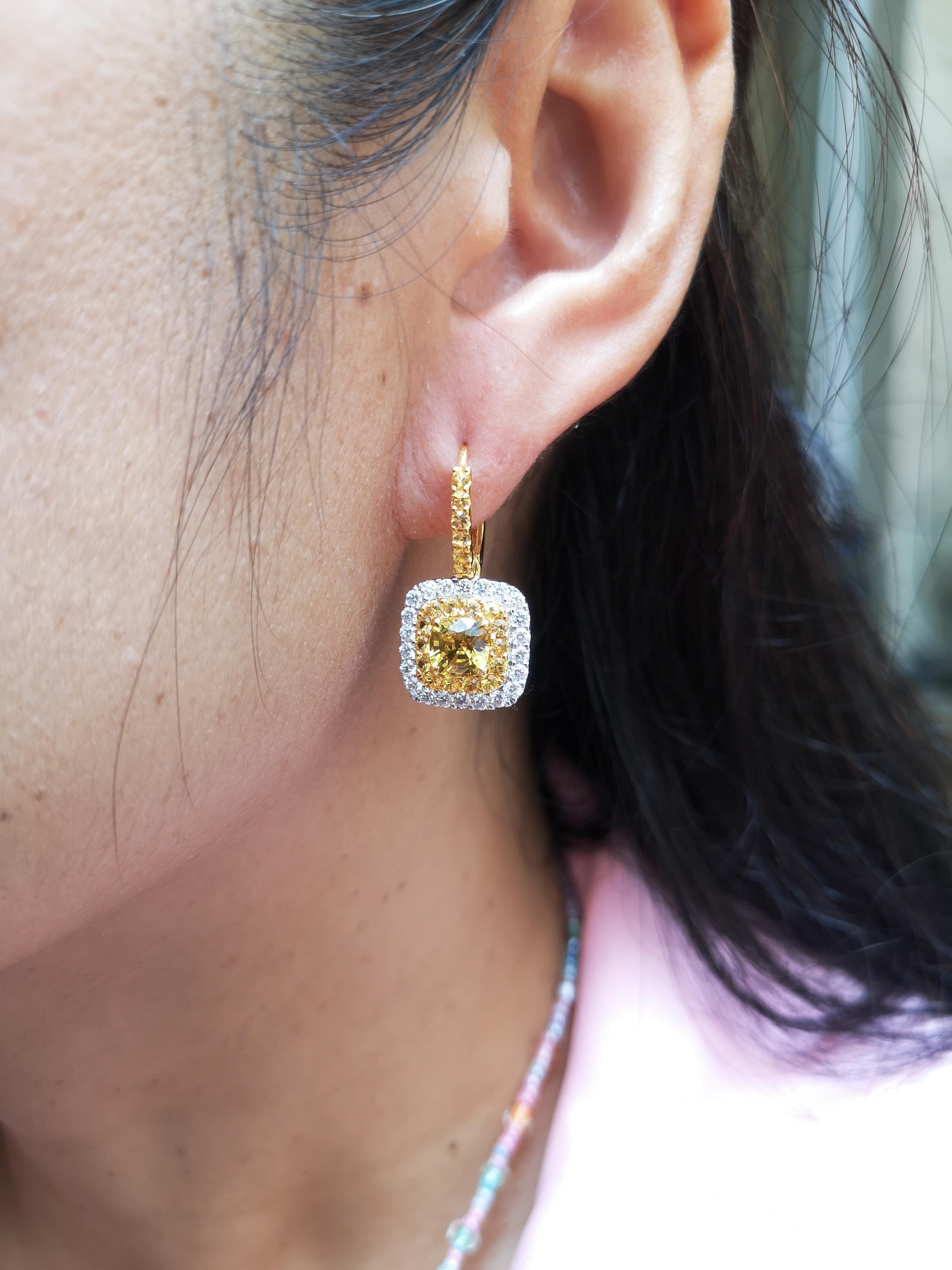 Boucles d'oreilles composées d'un saphir jaune de 2,31 carats, d'un saphir jaune de 1,14 carat et d'un diamant de 1,04 carat, le tout dans une monture en or blanc 18 carats

Largeur : 1,5 cm
Longueur : 2,5 cm 


