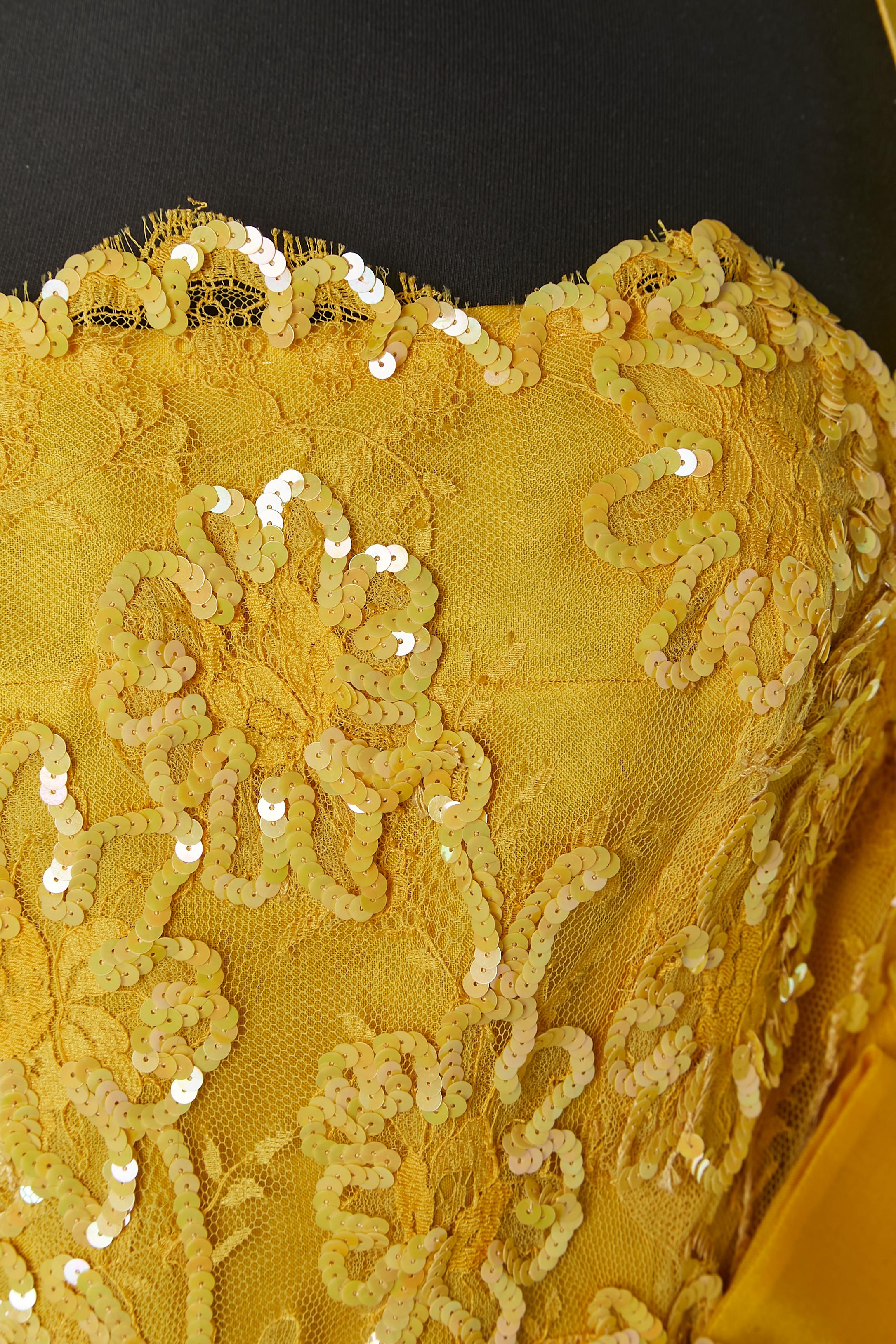 Gelbes Bustier-Cocktailkleid aus Seide, Spitze und Pailletten mit Schal. Seidenfutter. 
Verdeckter Reißverschluss auf der linken Seite. Bustier mit Knochen. Schleife 
Größe des Schals: 234cm X 34cm
SIZE 38 (Fr) M 