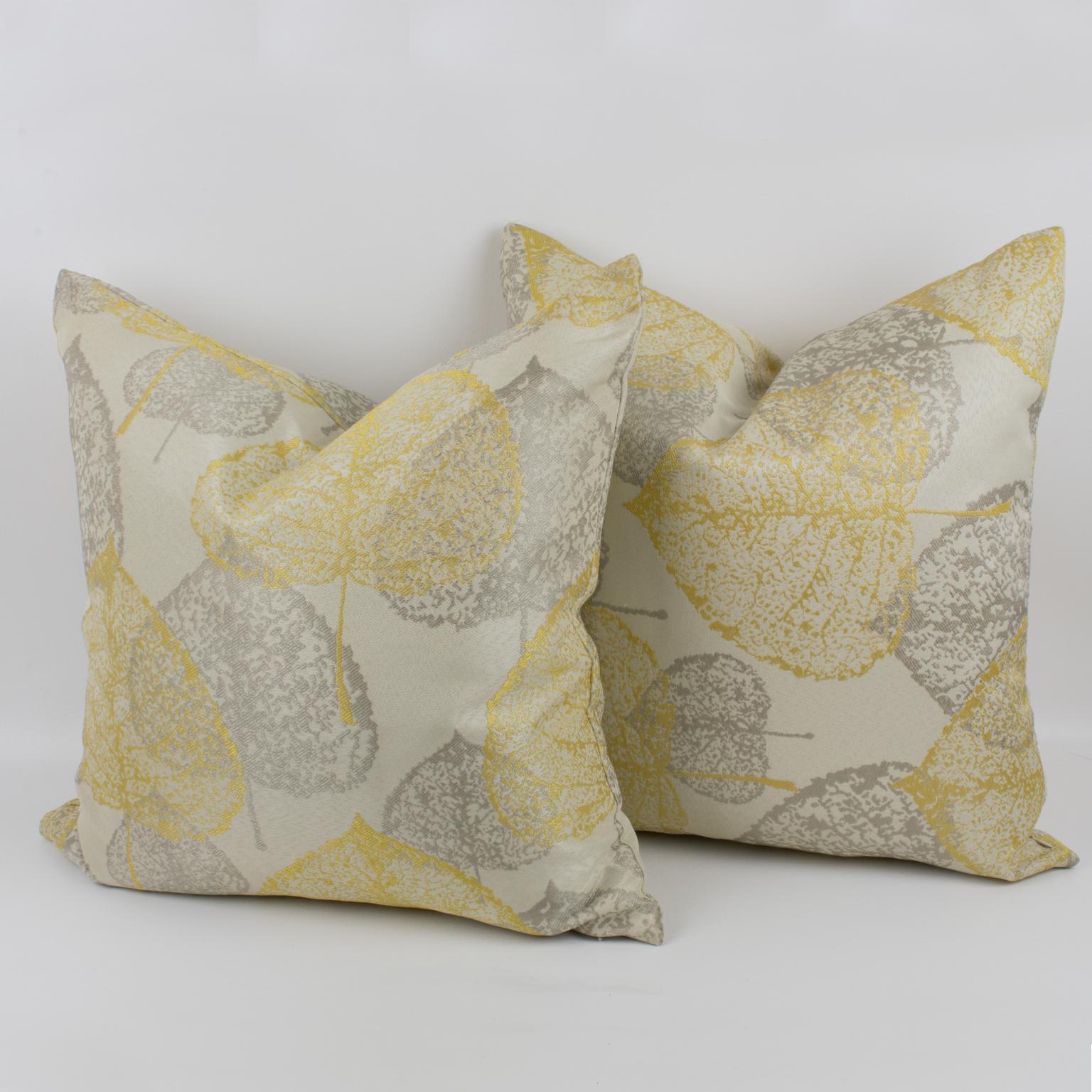 Lovely set of damask throw pillows. These lumbar pillows are covered with a textured naturalist design in silver-gray and light yellow colors over a silky off-white background. European shape. A zipper encloses an inner feather pillow. An accent for