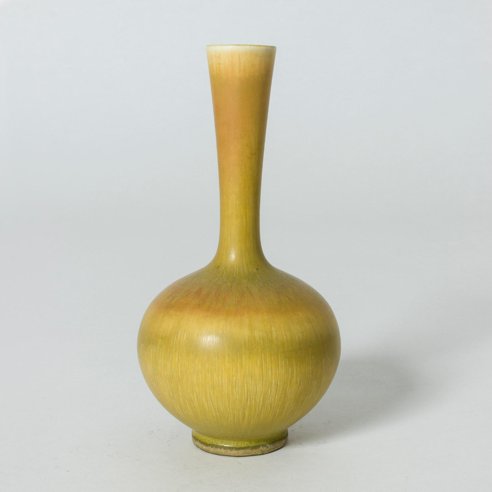 Elegant stoneware vase by Berndt Friberg, in a bulbous shape with a long neck. Warm yellow hare’s fur glaze.