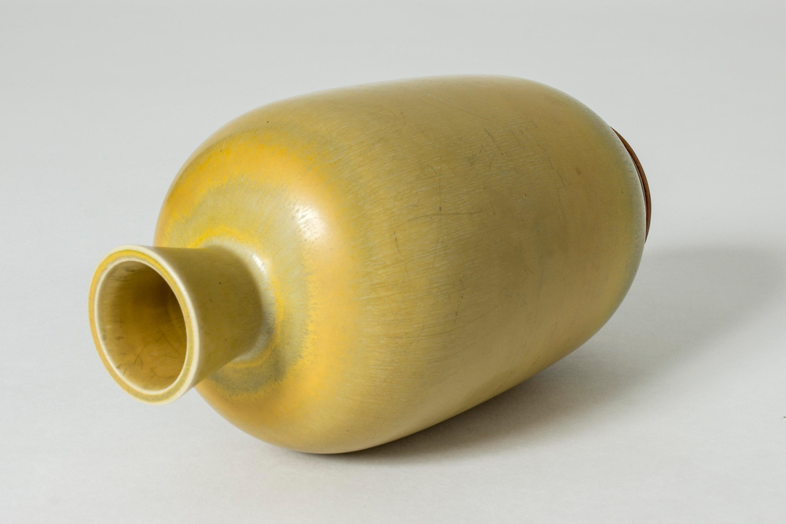Stoneware vase by Berndt Friberg, in an elegant, tall shape. Saturated yellow hare’s fur glaze with subtle green nuances at the base.