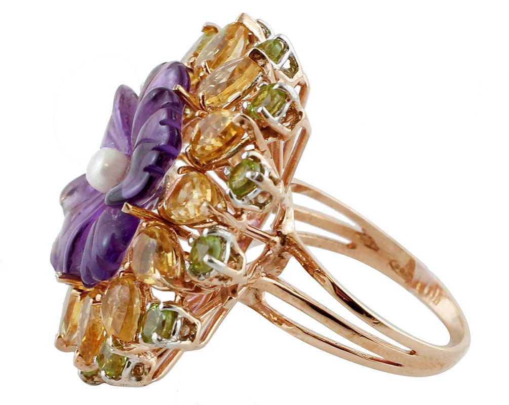 Gorgeous cocktail ring in 9 kt rose gold and silver structure mounted with, in the center, an hydrothermal amethyst and a small pearl. It is surrounded by drops yellow topaz and round peridots.
This ring is totally handmade by Italian master