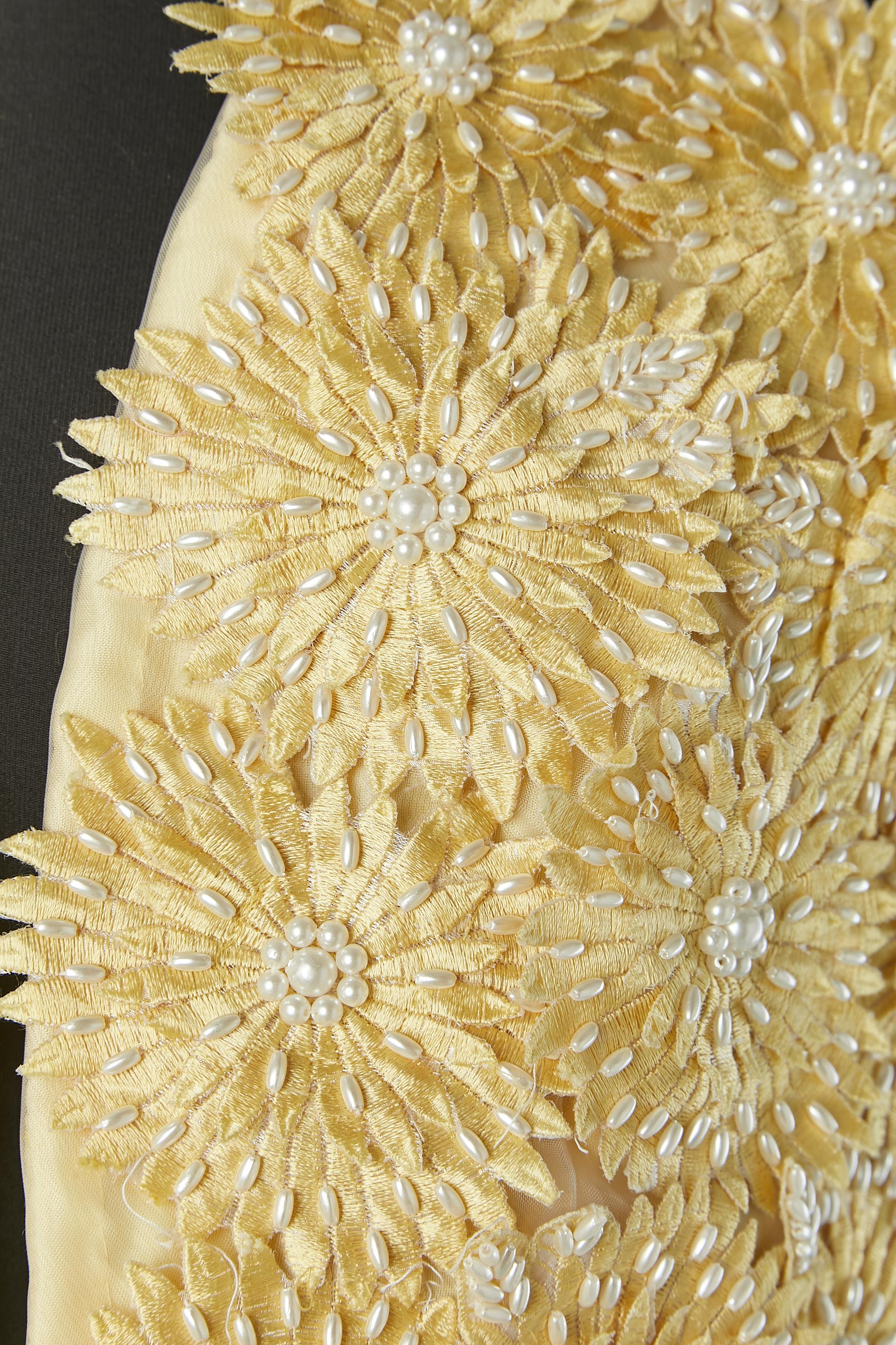 Yellow vest with thread flowers appliqué and beadwork. No fabric composition tag but the lining is probably in acetate and the flowers in rayon. 
SIZE M