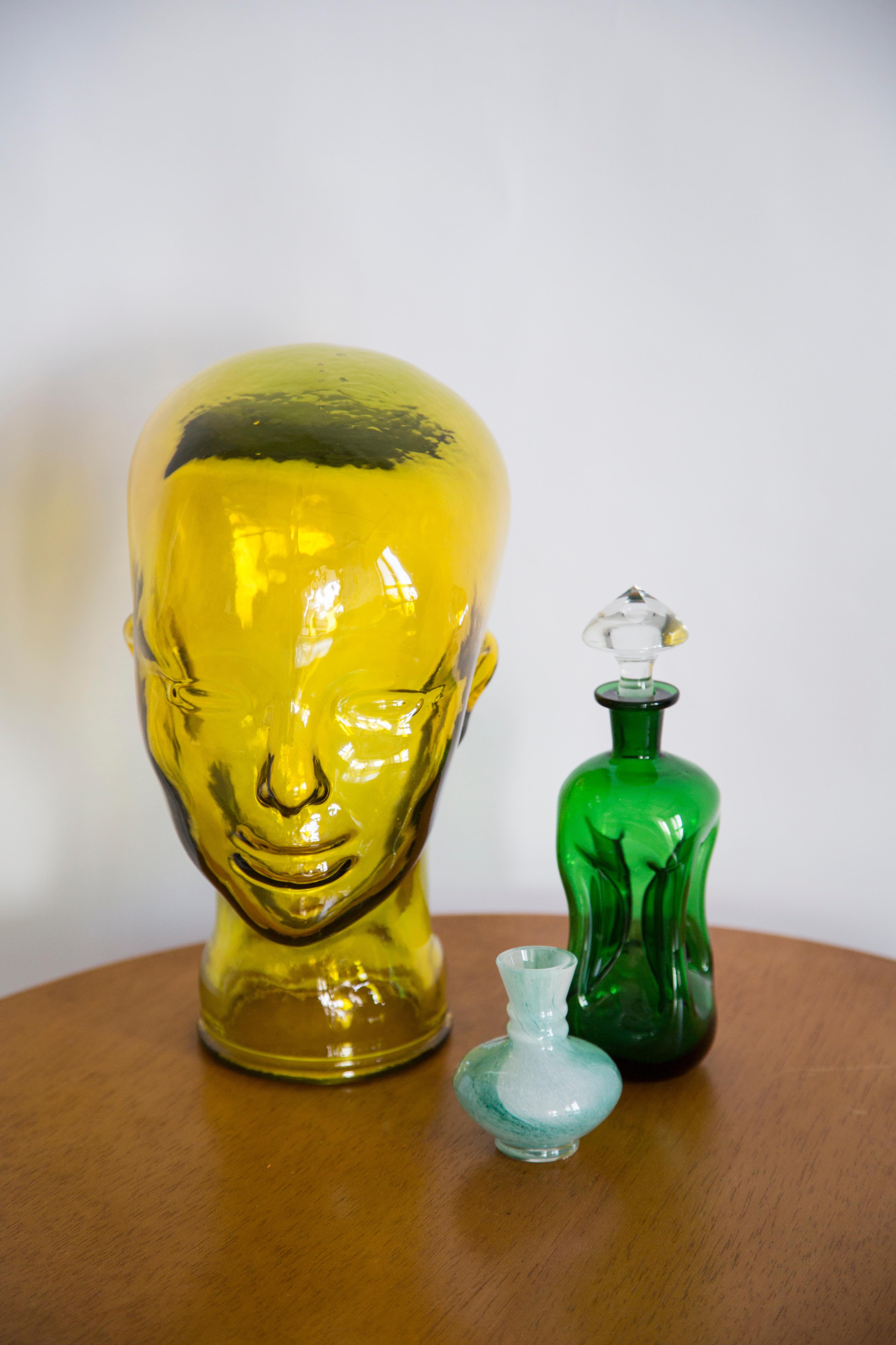 Life-size glass head in a unique yellow color. Produced in a German glassworks in the 1970s. Perfect condition. A perfect addition to the interior, photo prop, display or headphone stand.
